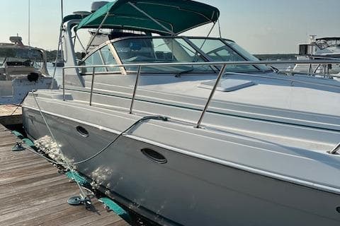 1997 Formula 34 PC boat docked, featuring sleek design and teal canopy.