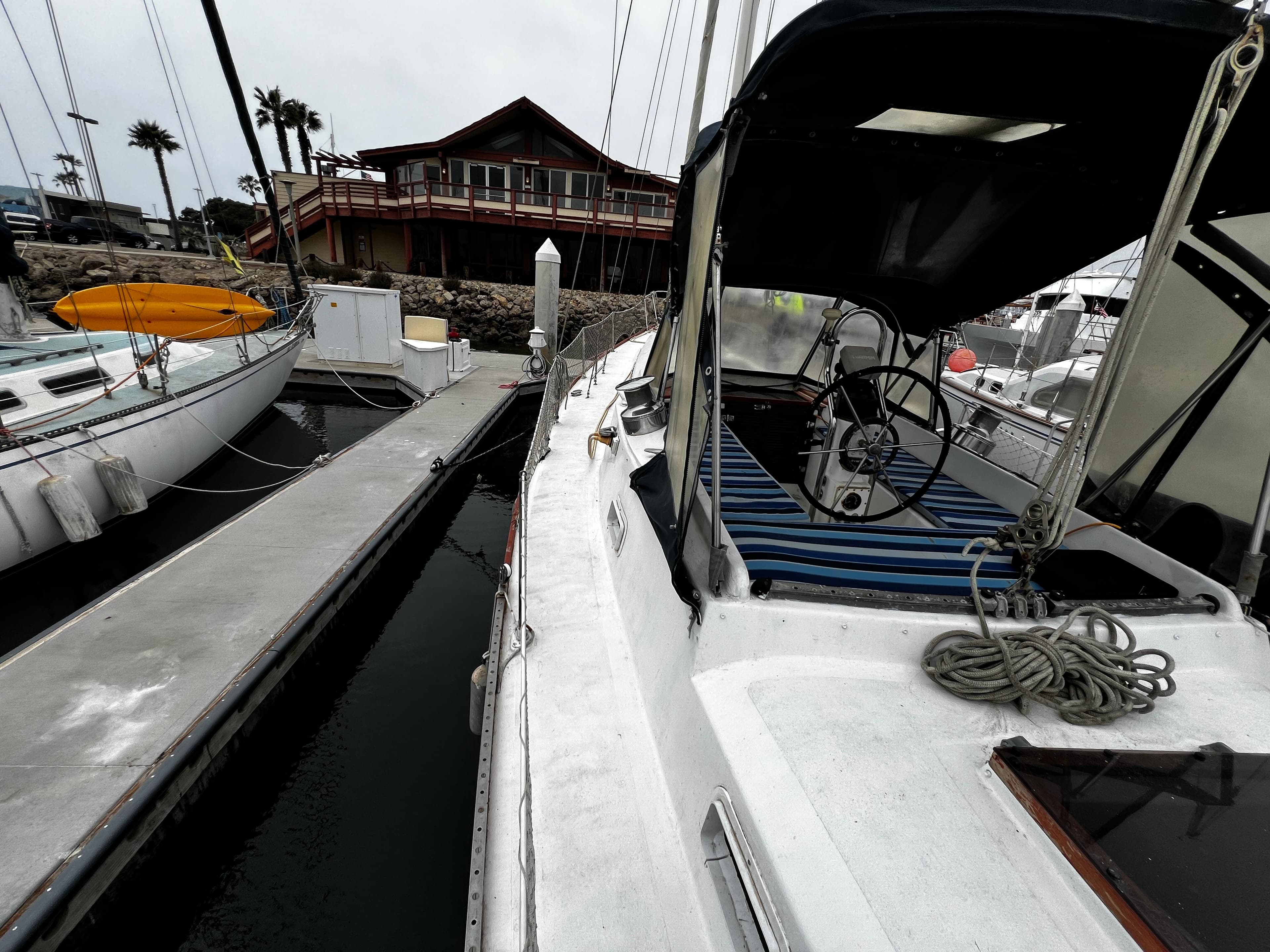 1974 Irwin 37 Center Cockpit sailboat docked at marina with nearby building.