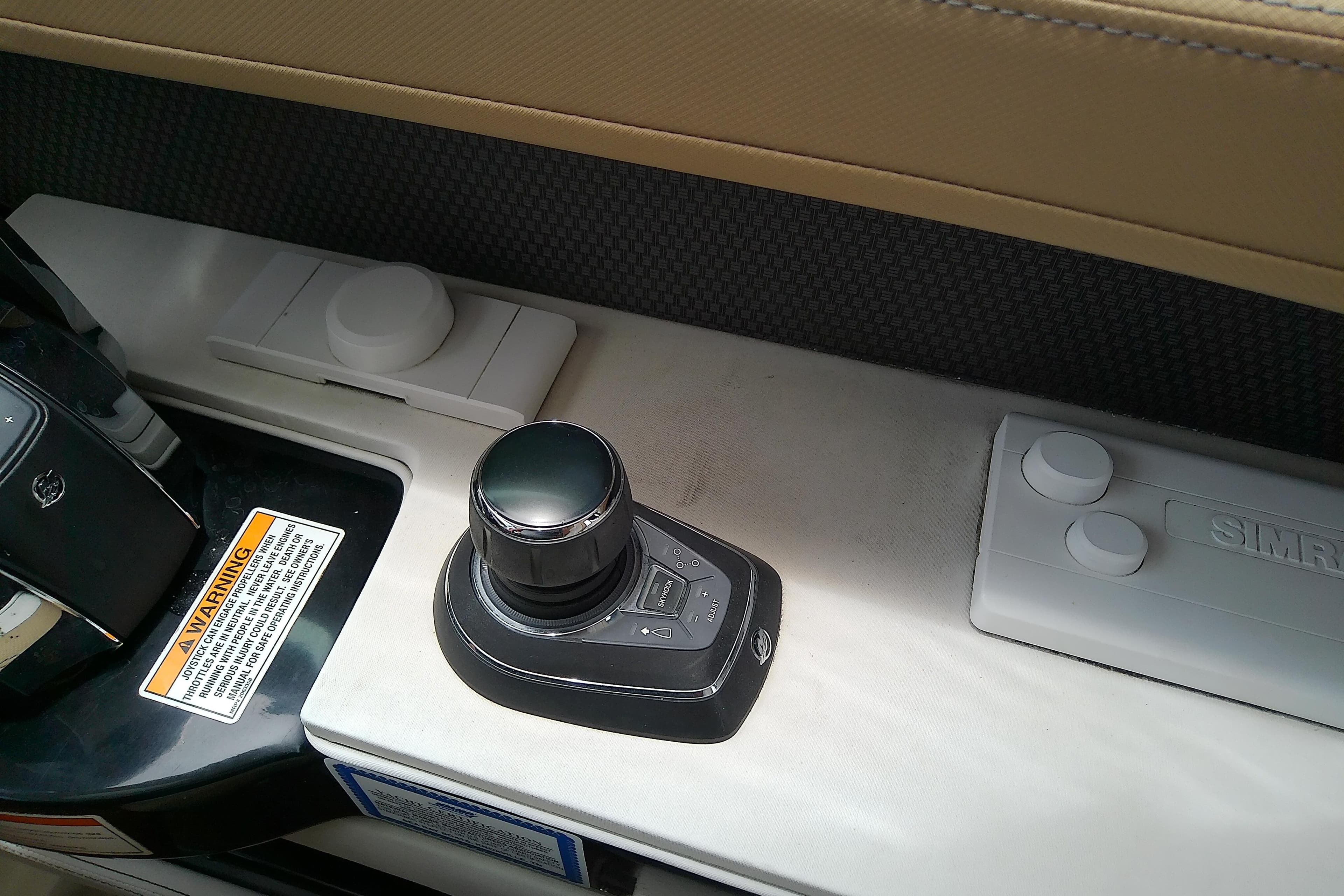 Control panel of a 2019 Sea Ray SLX 400 Outboard boat with joystick and warning label.