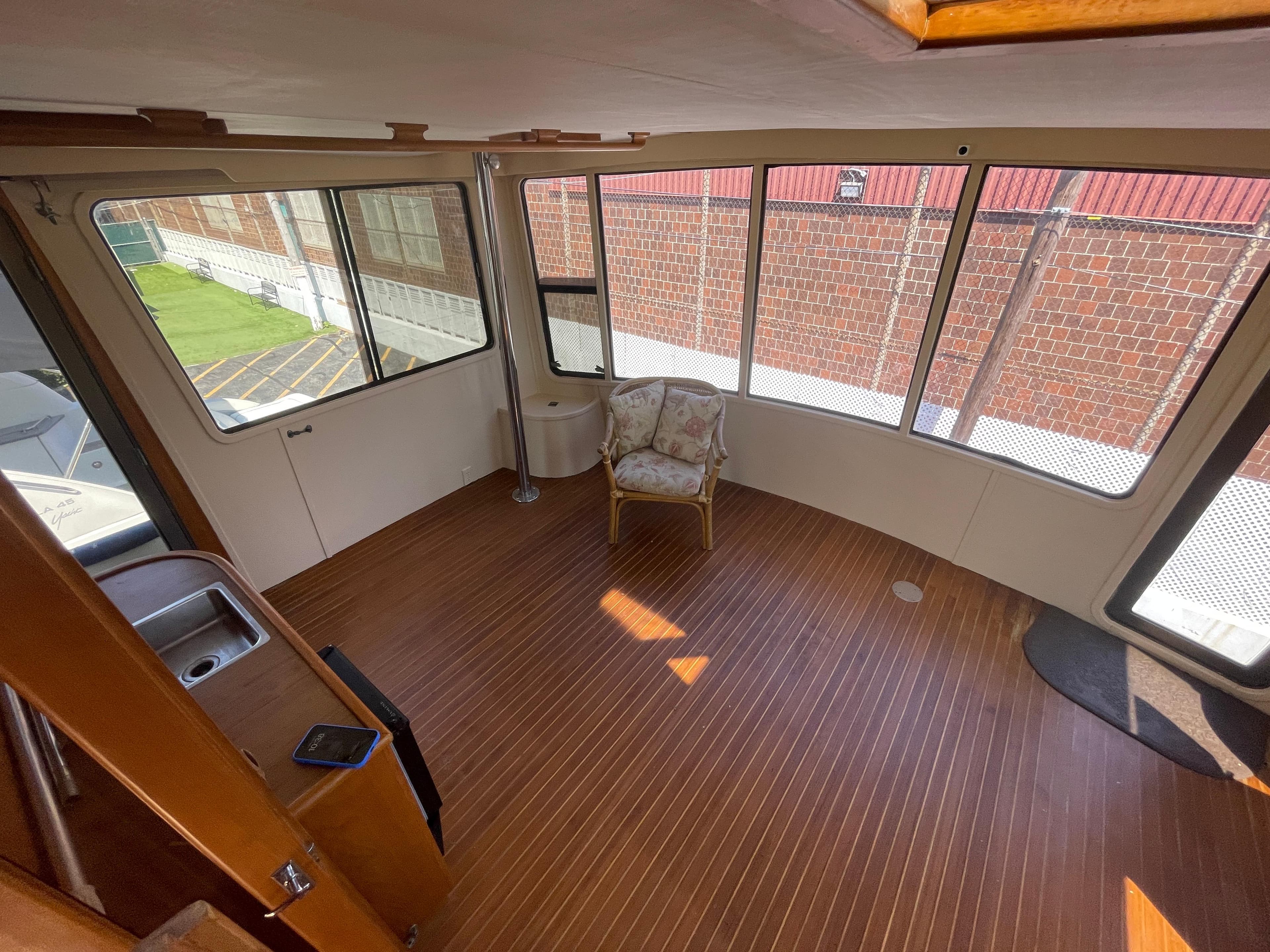 Interior of 1988 Vista 43 Motor Yacht with wooden flooring and large windows.