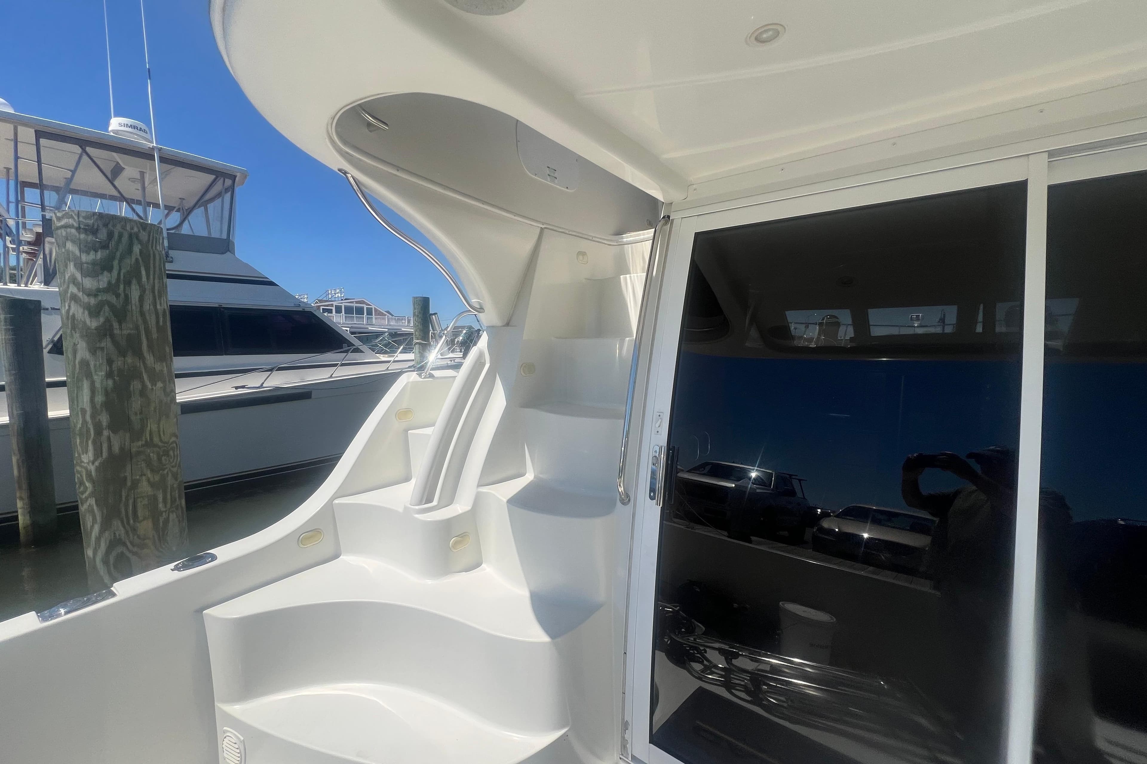 2004 Carver 360 Sport Sedan yacht with sleek white stairs and glass door in marina.