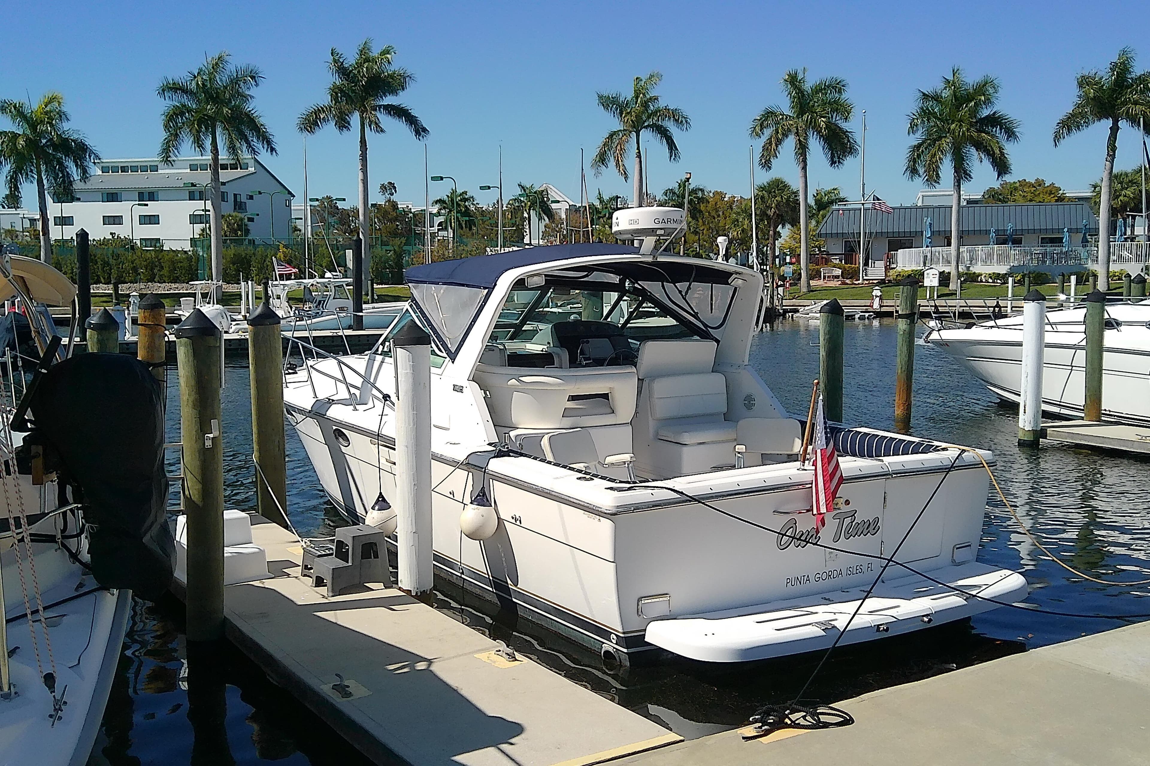 2000 Tiara Yachts 3100 Open docked at marina with palm trees in background.