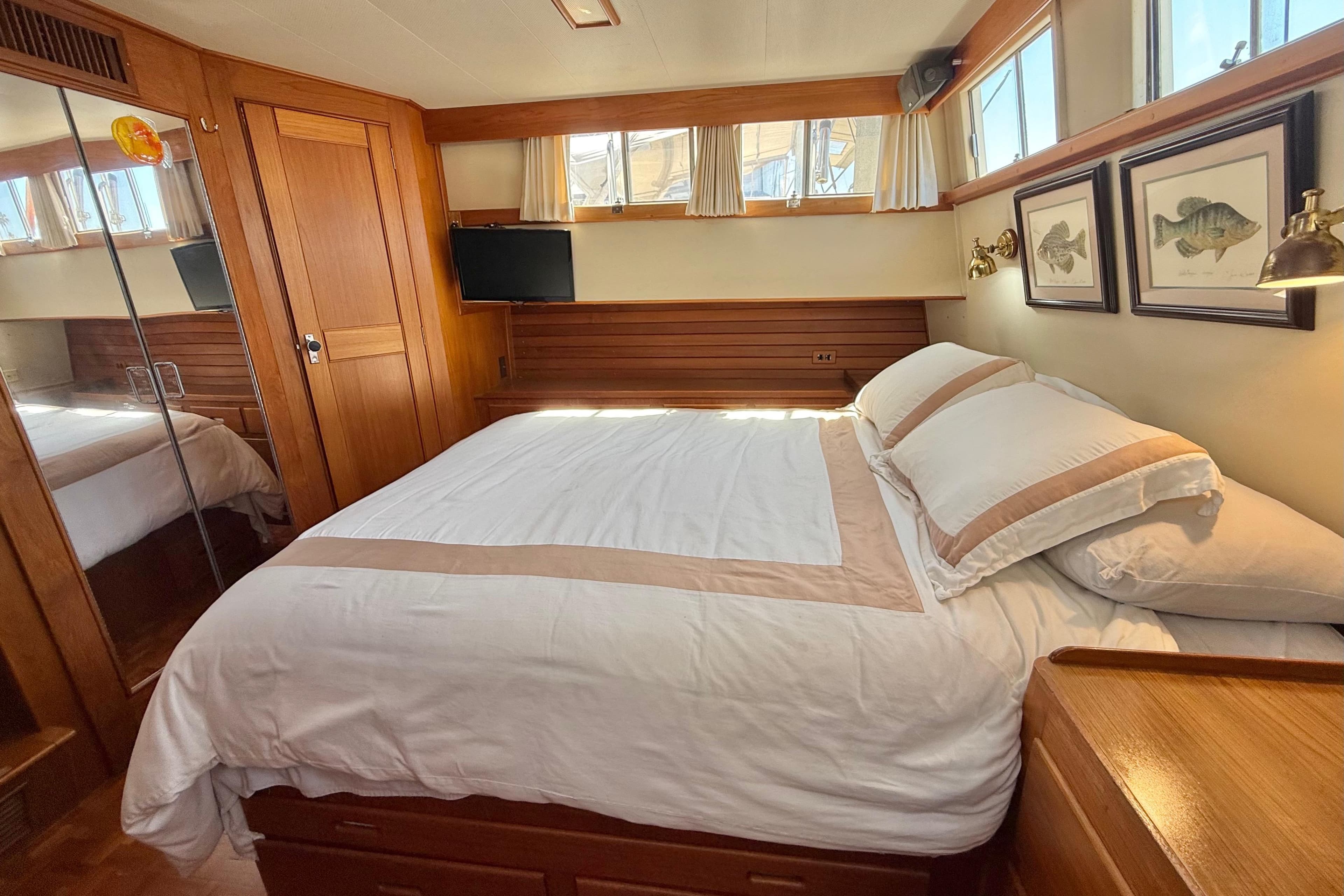 Luxurious 1992 Grand Banks 46 Classic yacht bedroom with elegant wood paneling and cozy bedding.