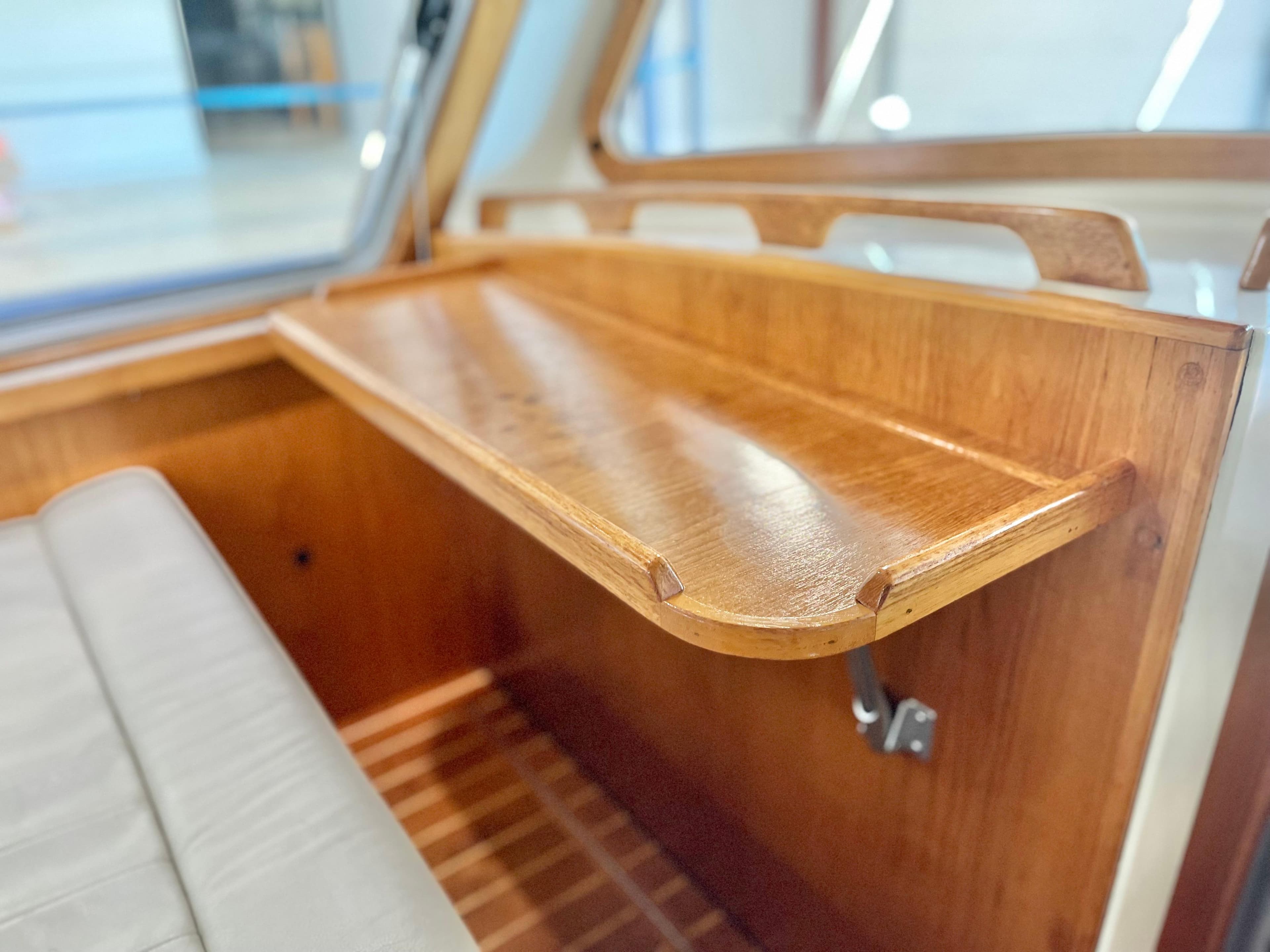 Wooden interior detail of a 2007 Coastal Craft 36 Cruiser boat, featuring a foldable table.