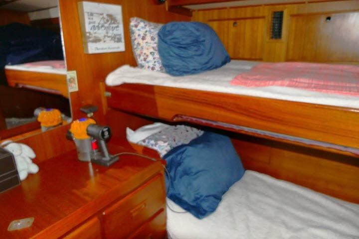 Interior of 1982 Ta Shing Mason 63 yacht with wooden bunk beds and cozy decor.