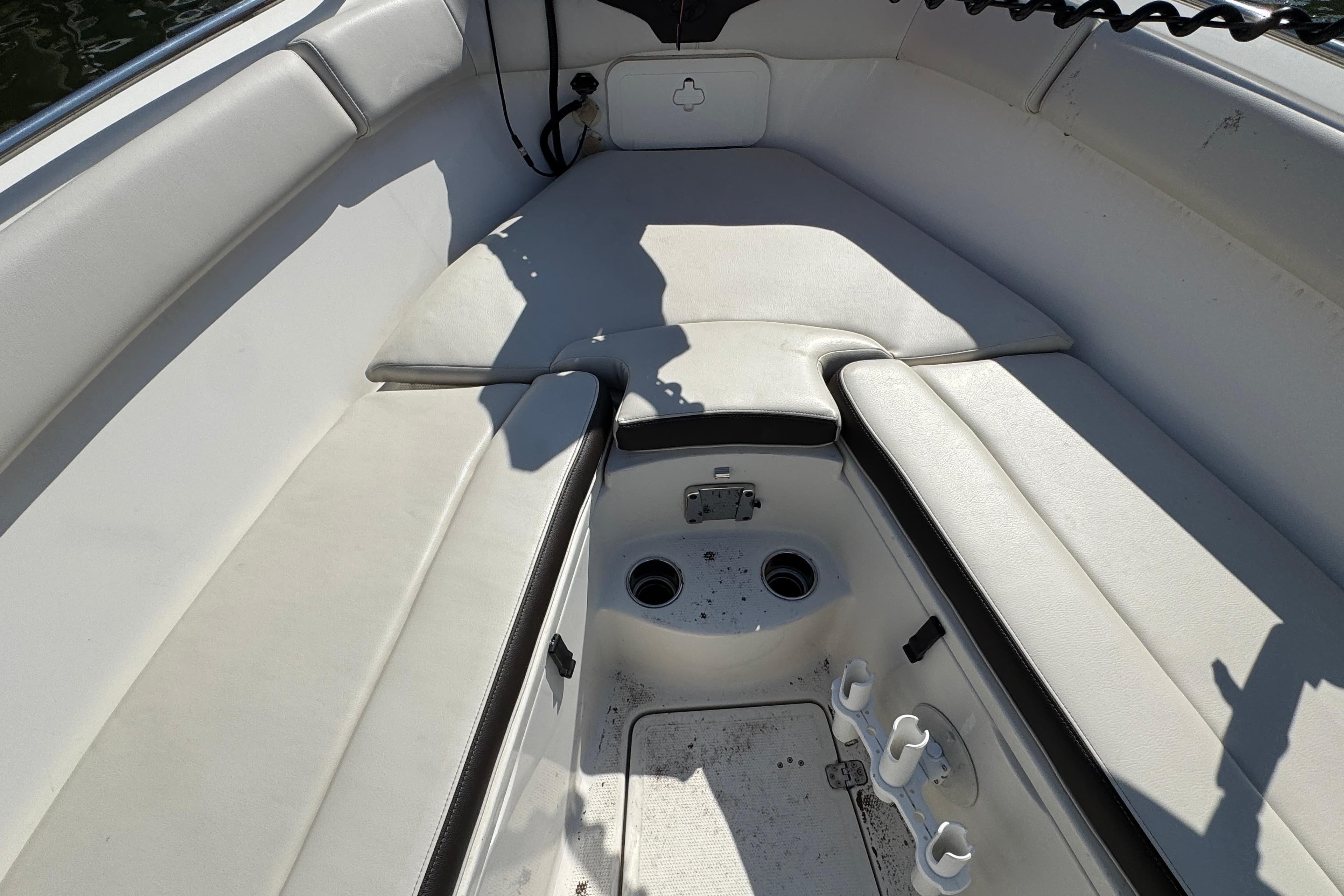 Interior of 2022 Sailfish 242 CC boat with cushioned seating and storage compartments.
