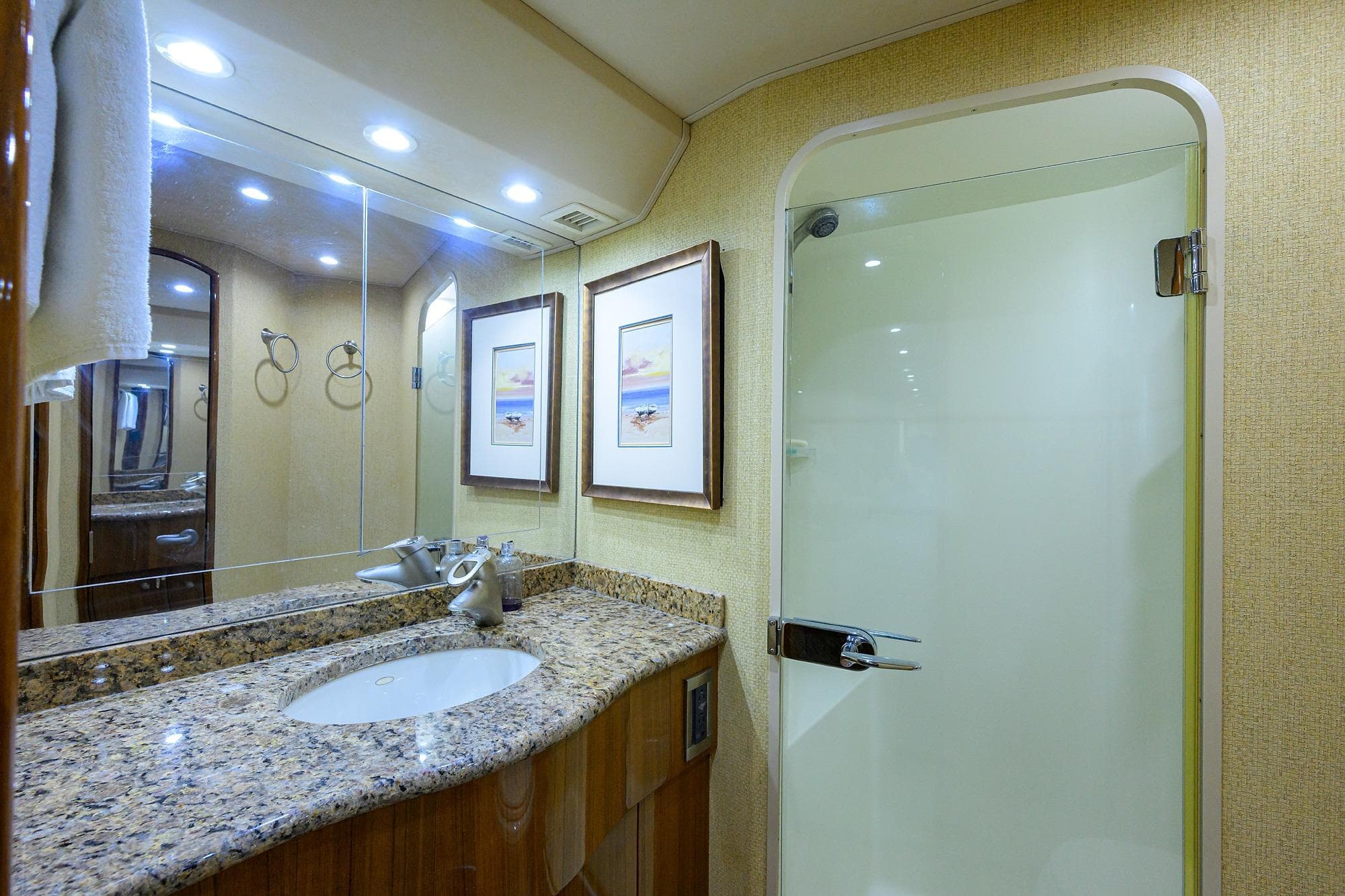 Luxurious bathroom in 2007 Viking 56 Convertible yacht with granite countertop and glass shower.