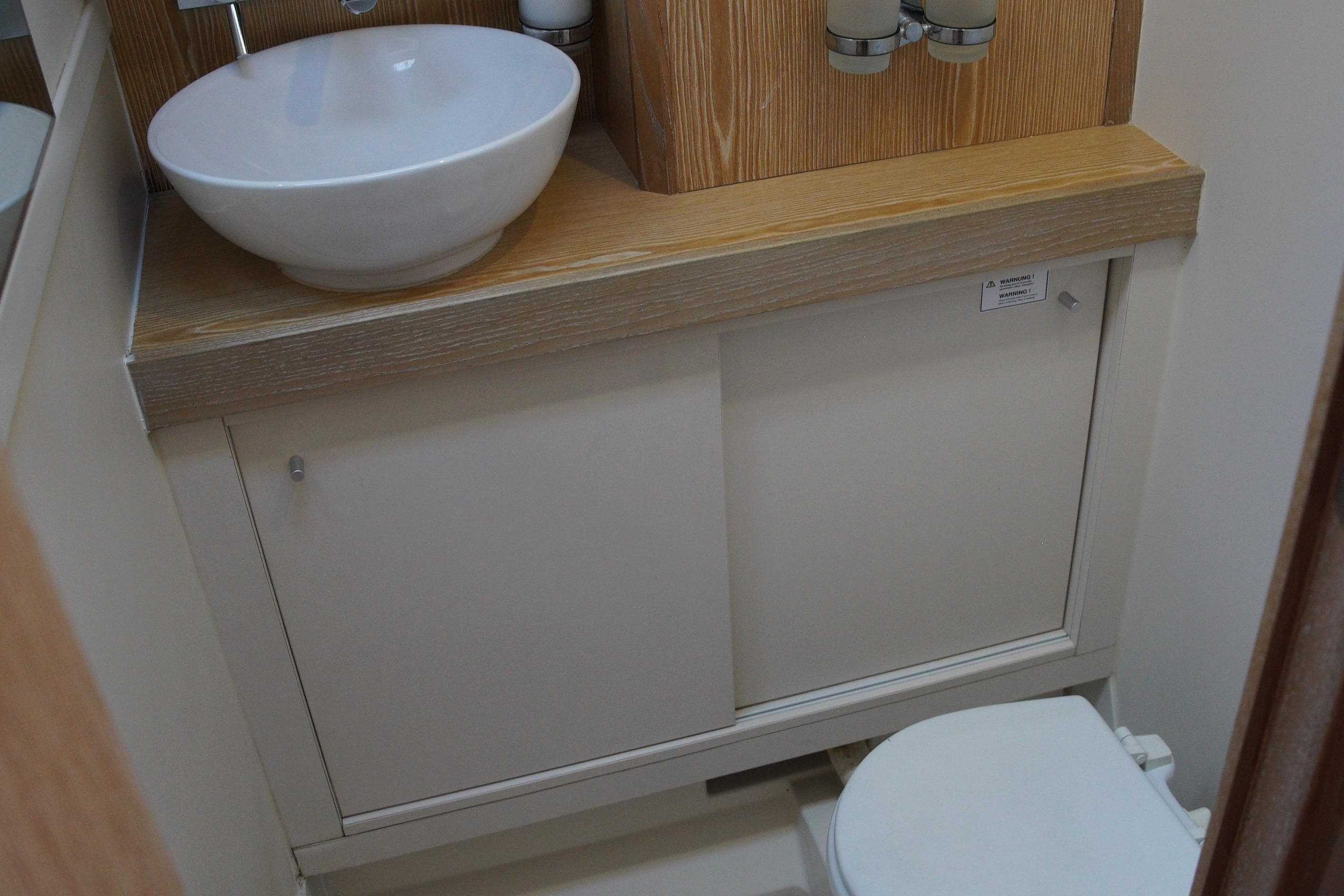 Bathroom interior of 2013 Hanse 575 yacht with sink and toilet.