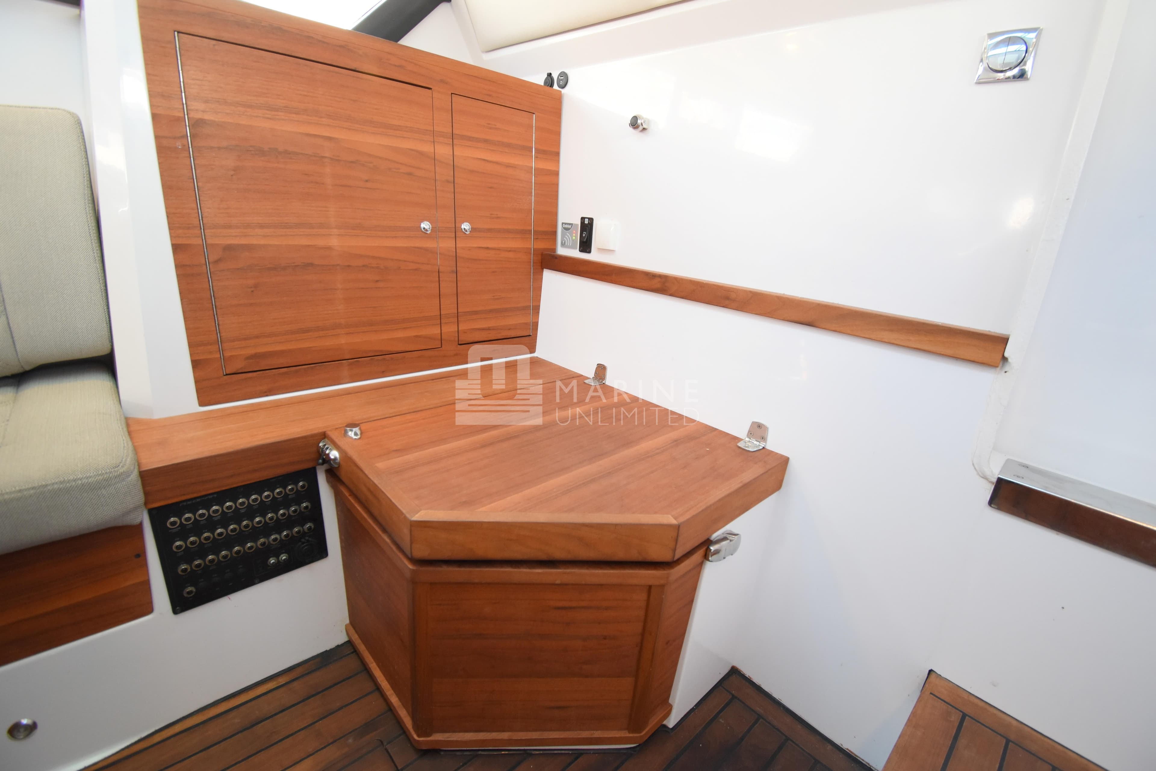 Interior of 2016 Axopar 37 Sun-Top boat with wooden cabinetry and seating.