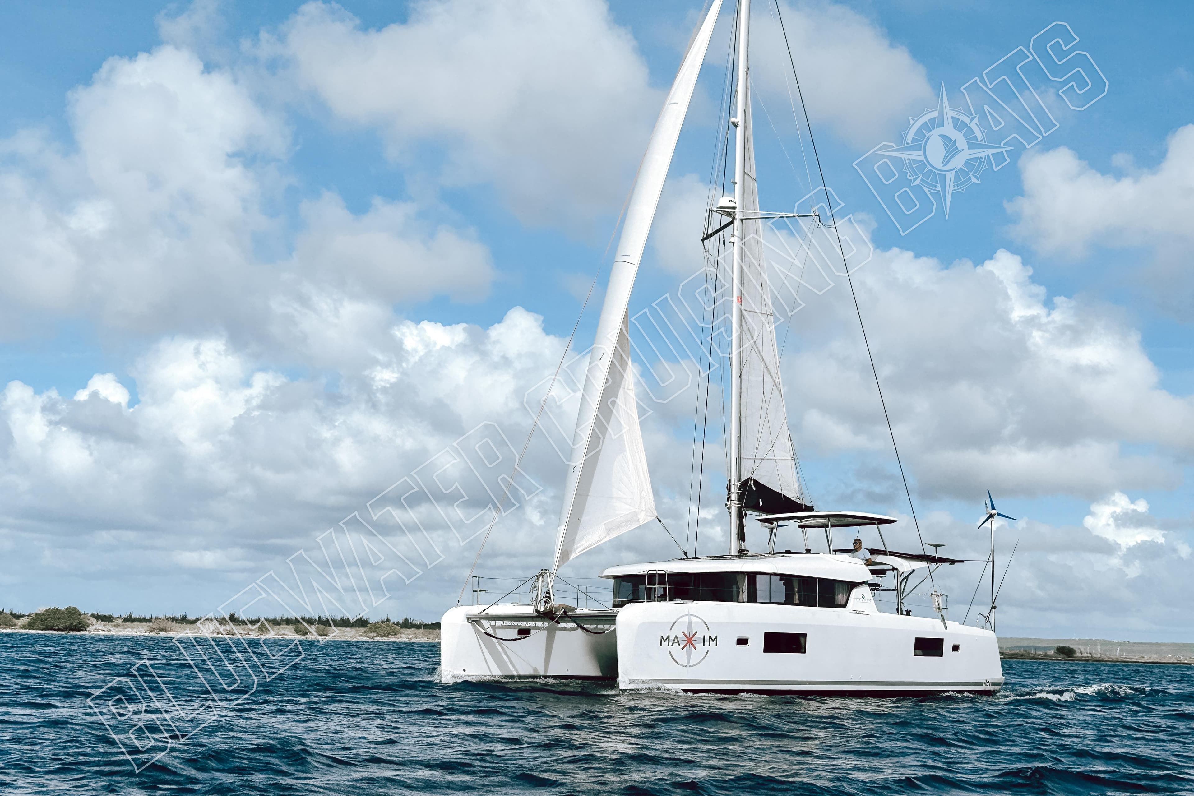 2018 Lagoon 42 catamaran sailing on open water under a cloudy sky.