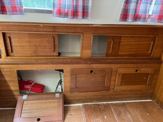 1978 Bristol 29.9 interior with wooden cabinets and plaid curtains.