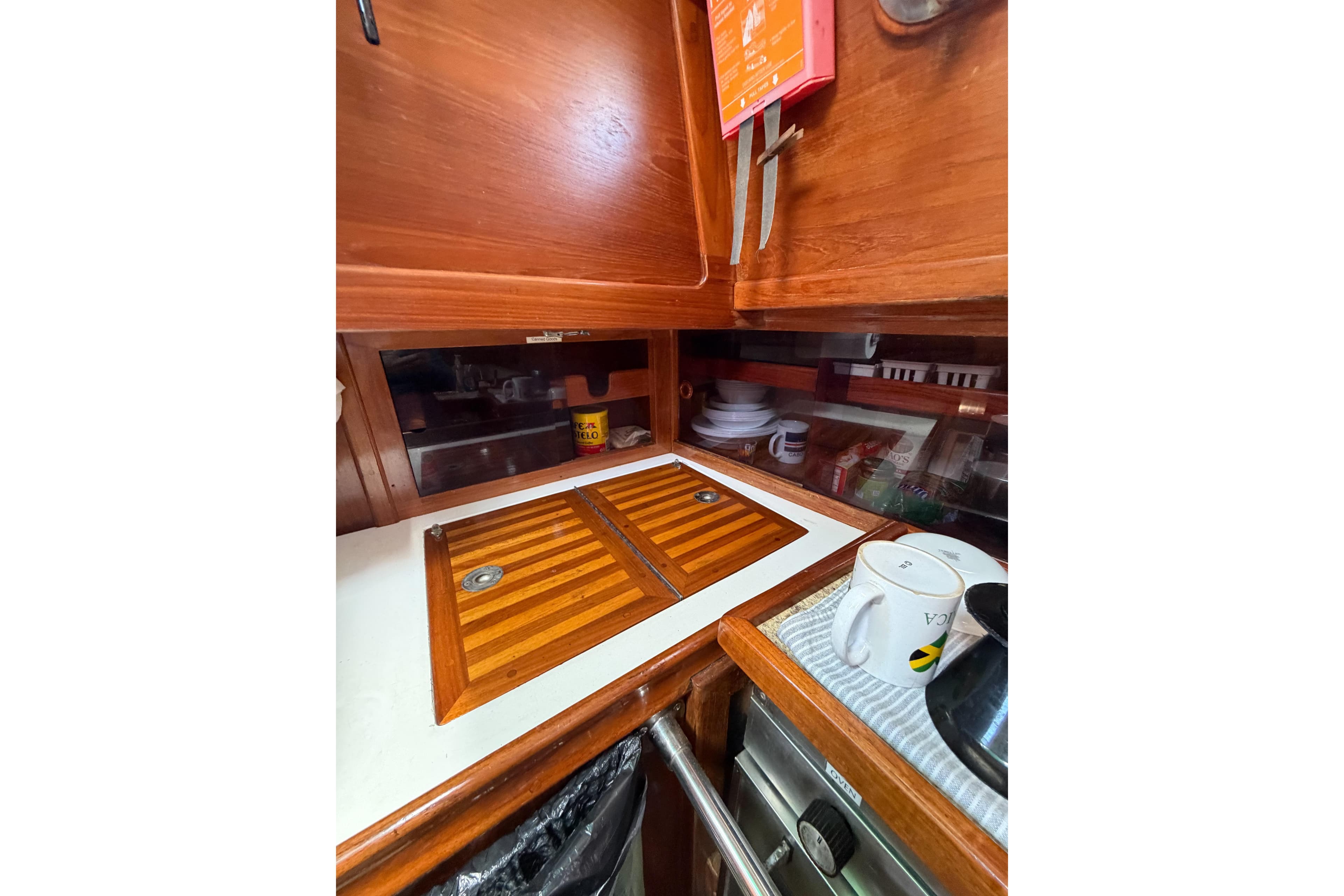 Interior of 1989 Cabo Rico 34 sailboat galley with wooden cabinetry and countertop.