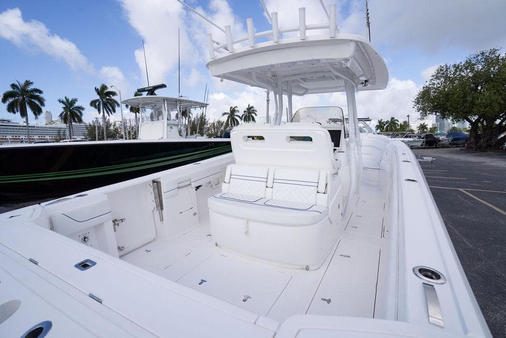2022 Intrepid 345 Nomad FE boat with spacious deck and seating, docked under a blue sky.