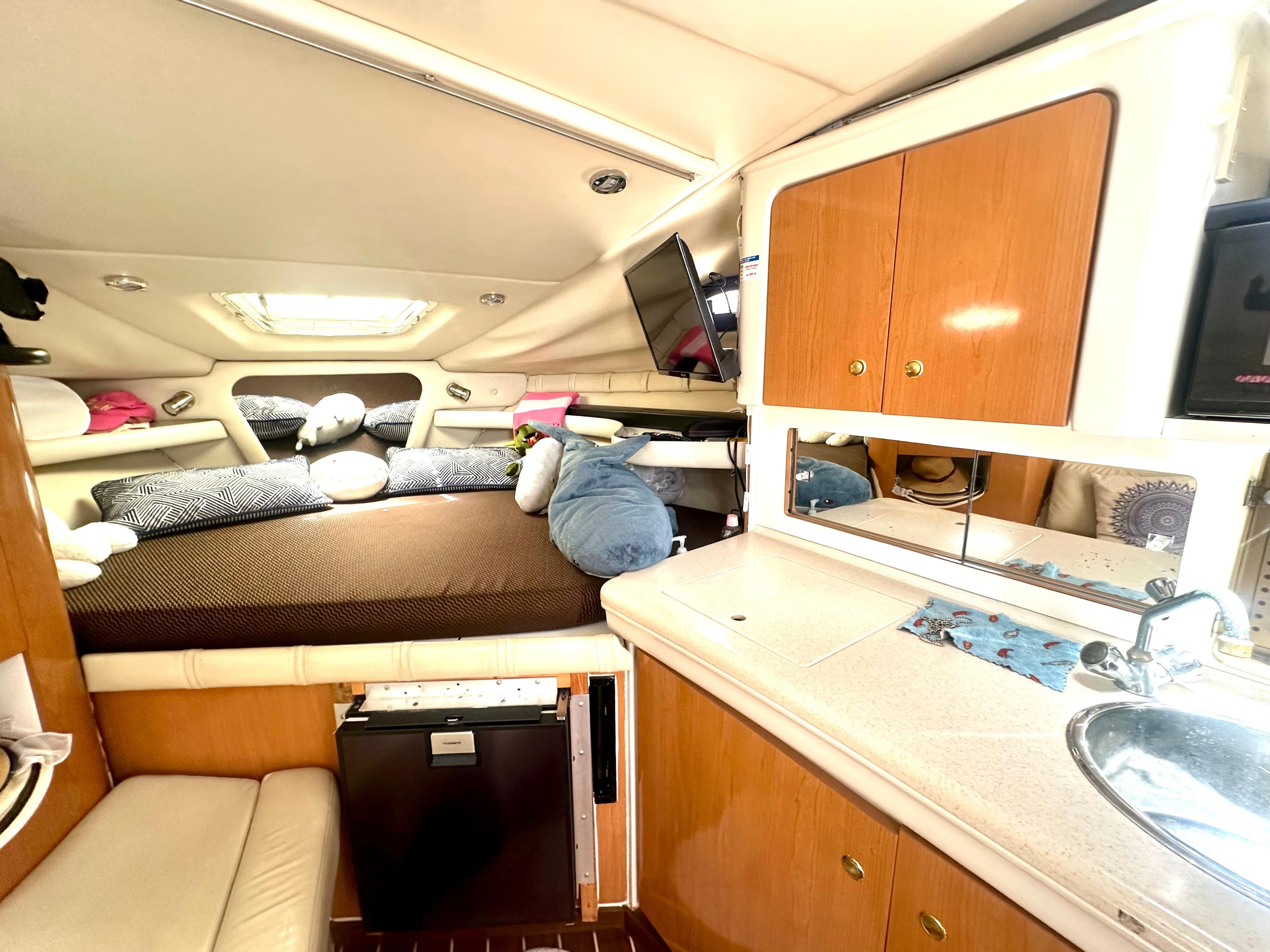2001 Regal Commodore 2760 cabin interior with bed, kitchenette, and storage cabinets.