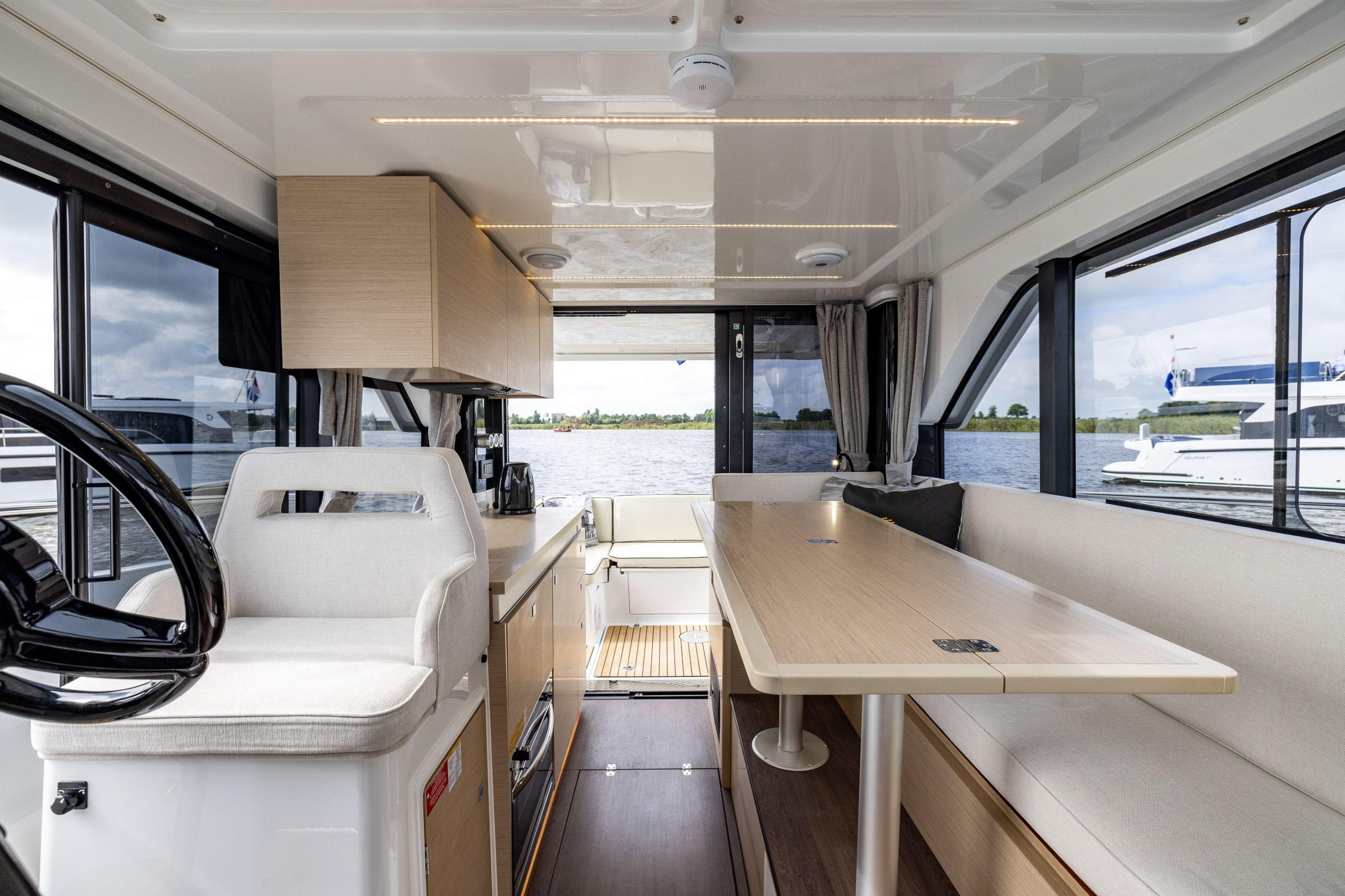 Interior of 2026 Delphia D10 Sedan yacht with modern seating and panoramic windows.