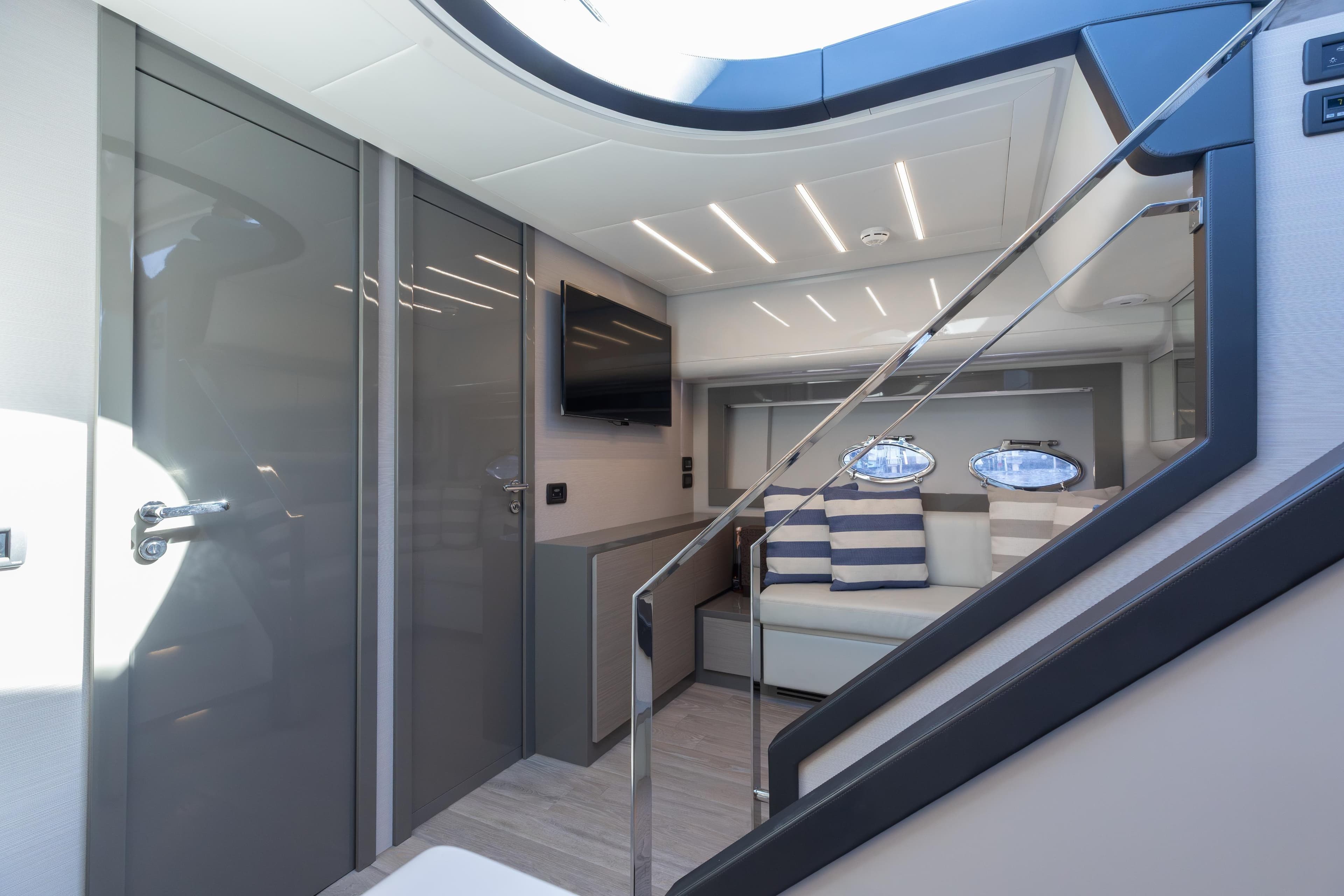 Luxurious interior of 2016 Pershing 62 yacht with modern design and striped cushions.