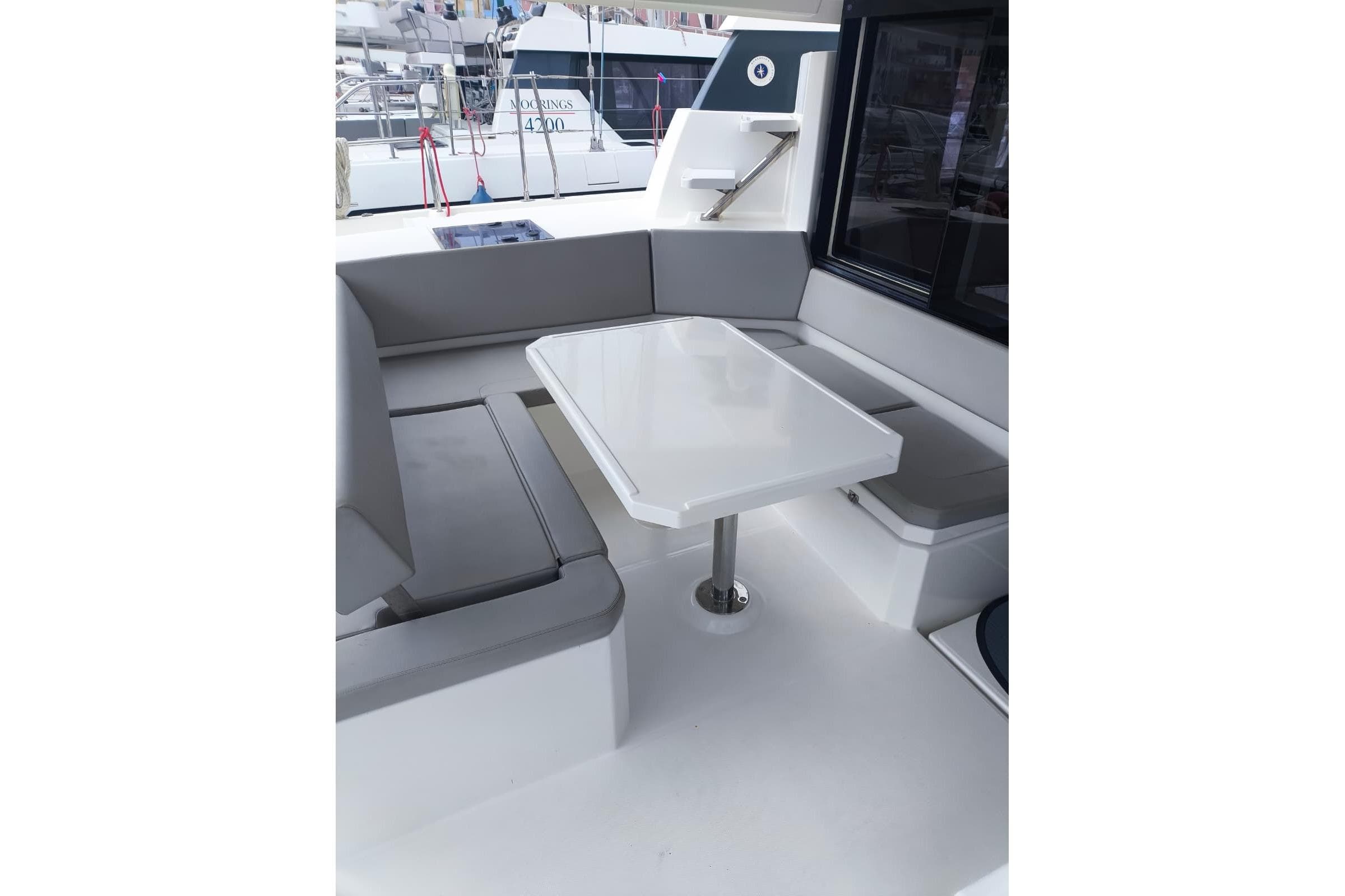 Modern seating area on a 2021 Leopard 42 catamaran with sleek table and cushioned benches.