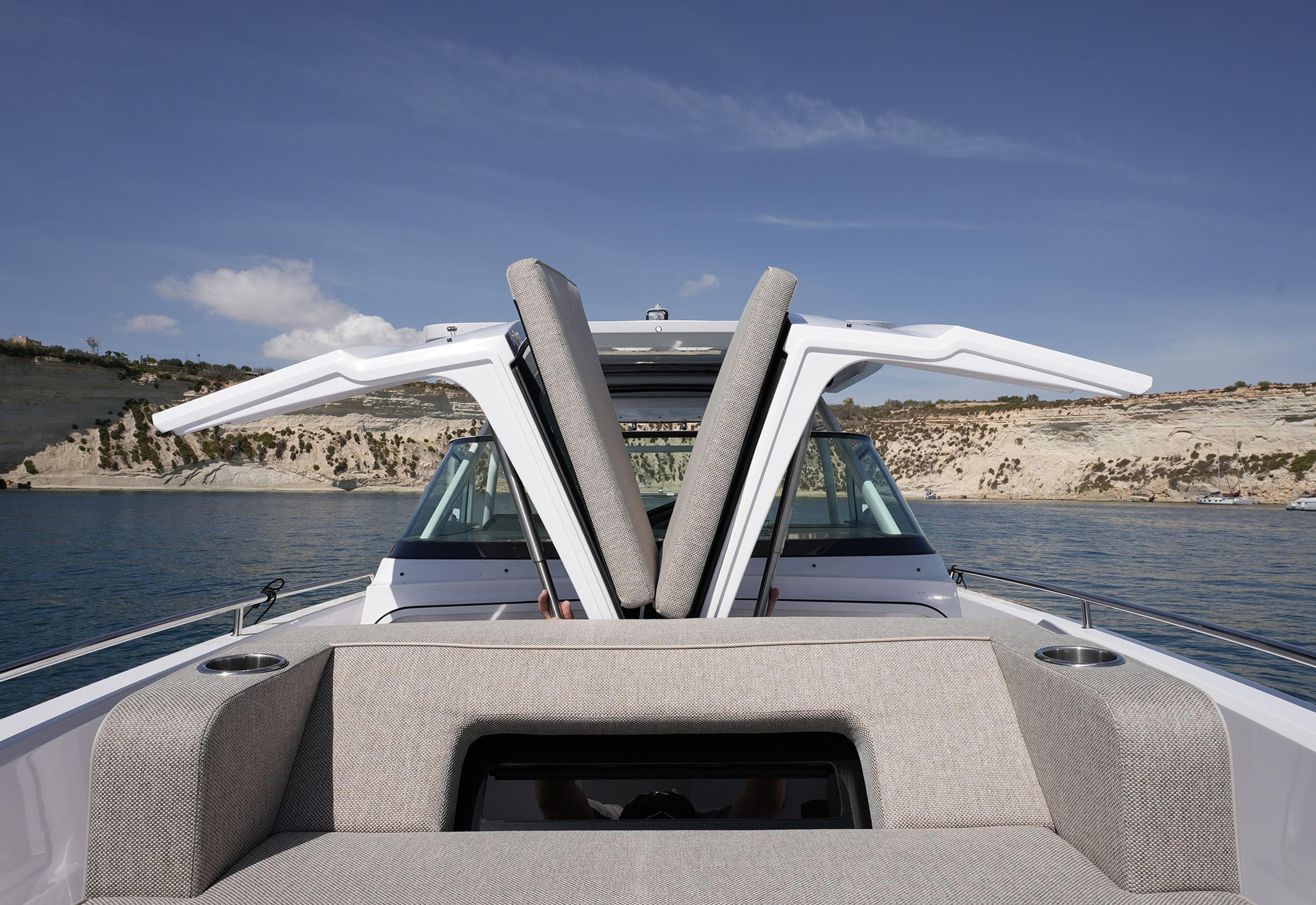2023 Axopar 37 Sun Top boat with open sunroof on calm water.