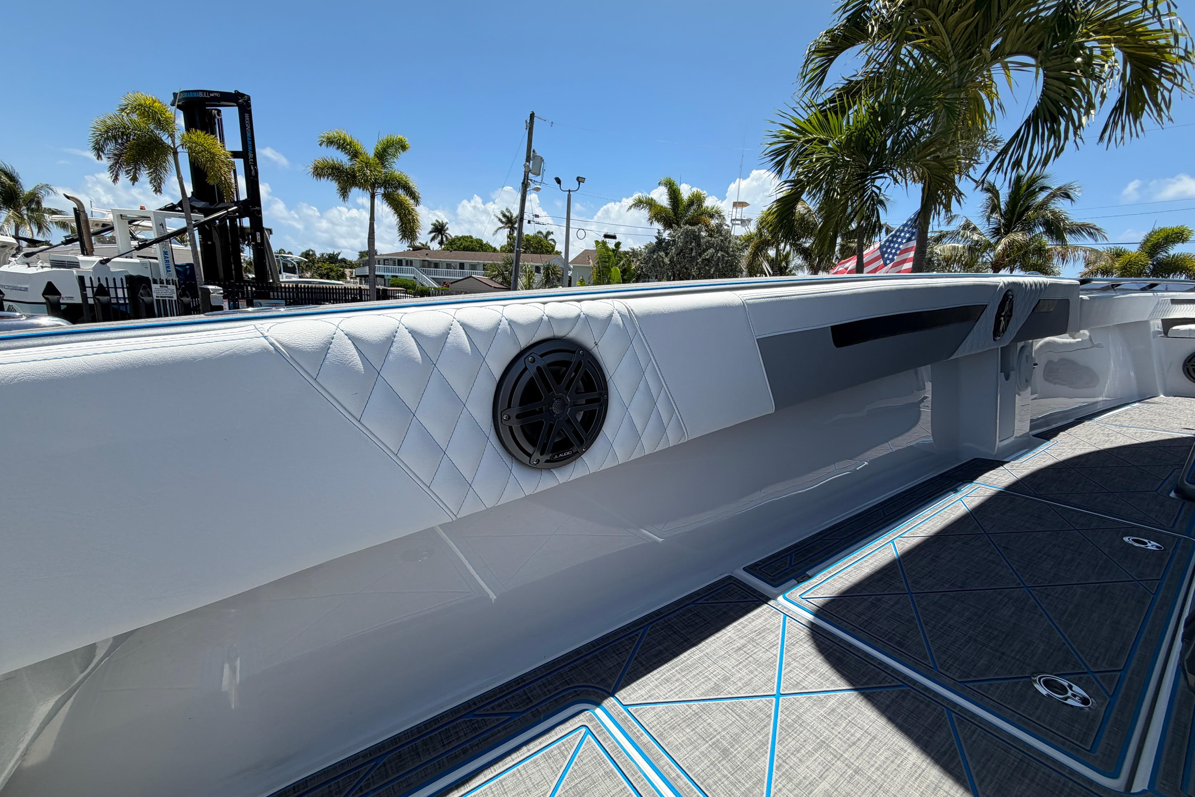 2027 Statement 350 Open boat interior with sleek design, featuring speakers and palm trees in the background.