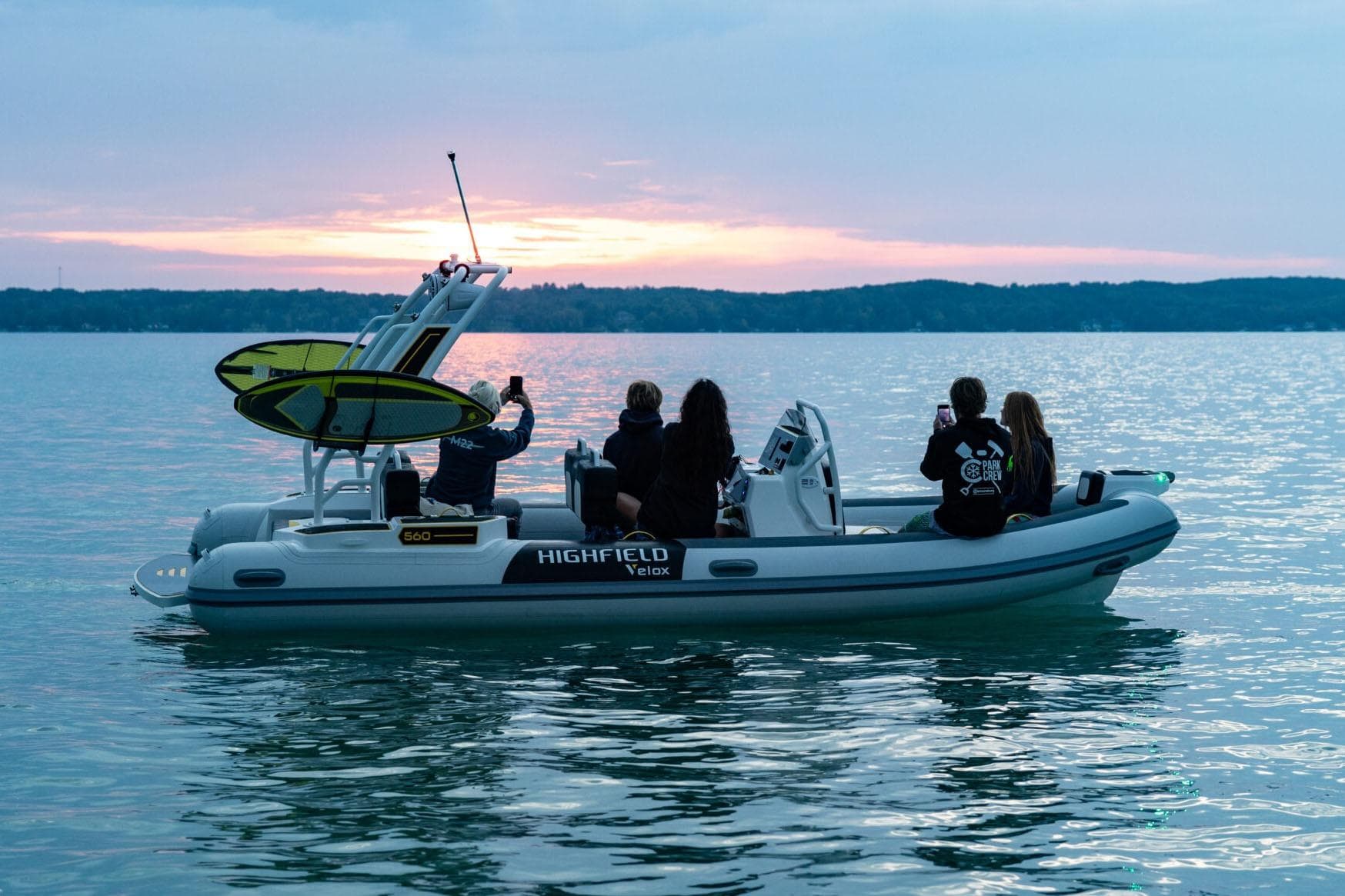 Manufacturer Provided Image: Highfield VELOX 560 boat on water at sunset, 2025 model, with passengers enjoying the view.