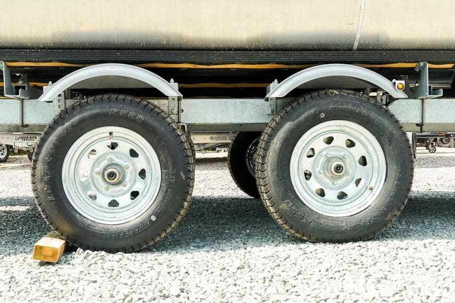 Trailer wheels on a 2026 Dockside 22DF, parked on gravel.