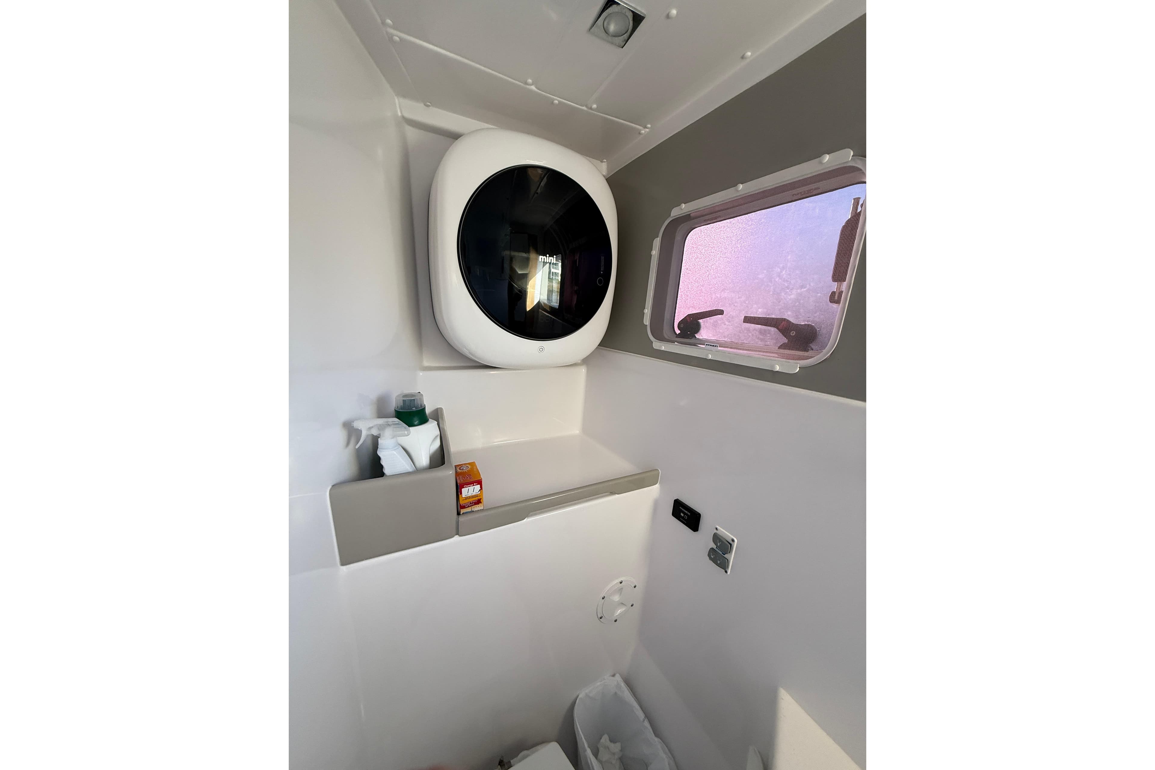2024 Seawind 1370 interior with compact washing machine and window view.