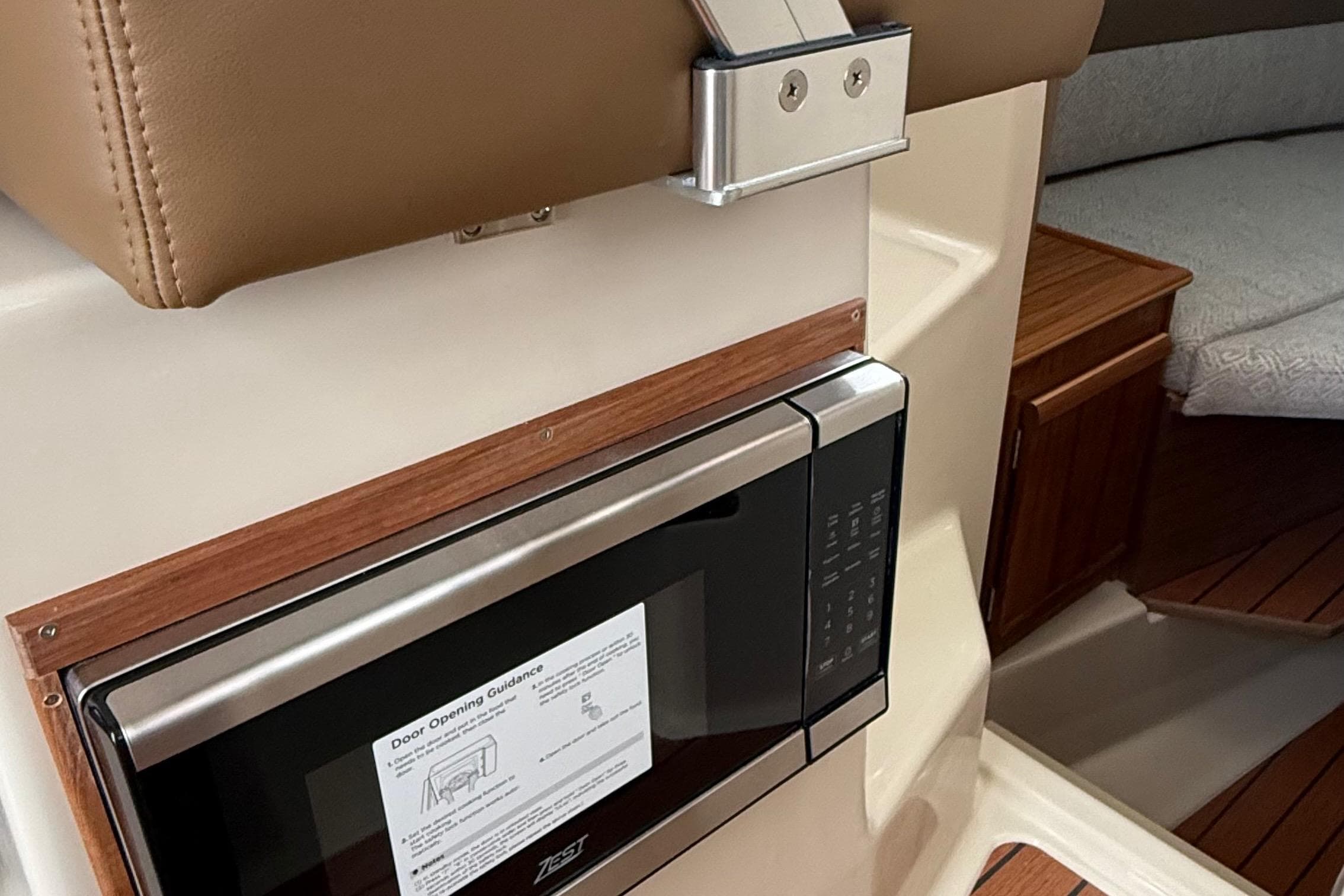 2025 Ranger Tugs R-25 interior with microwave and wooden cabinetry.