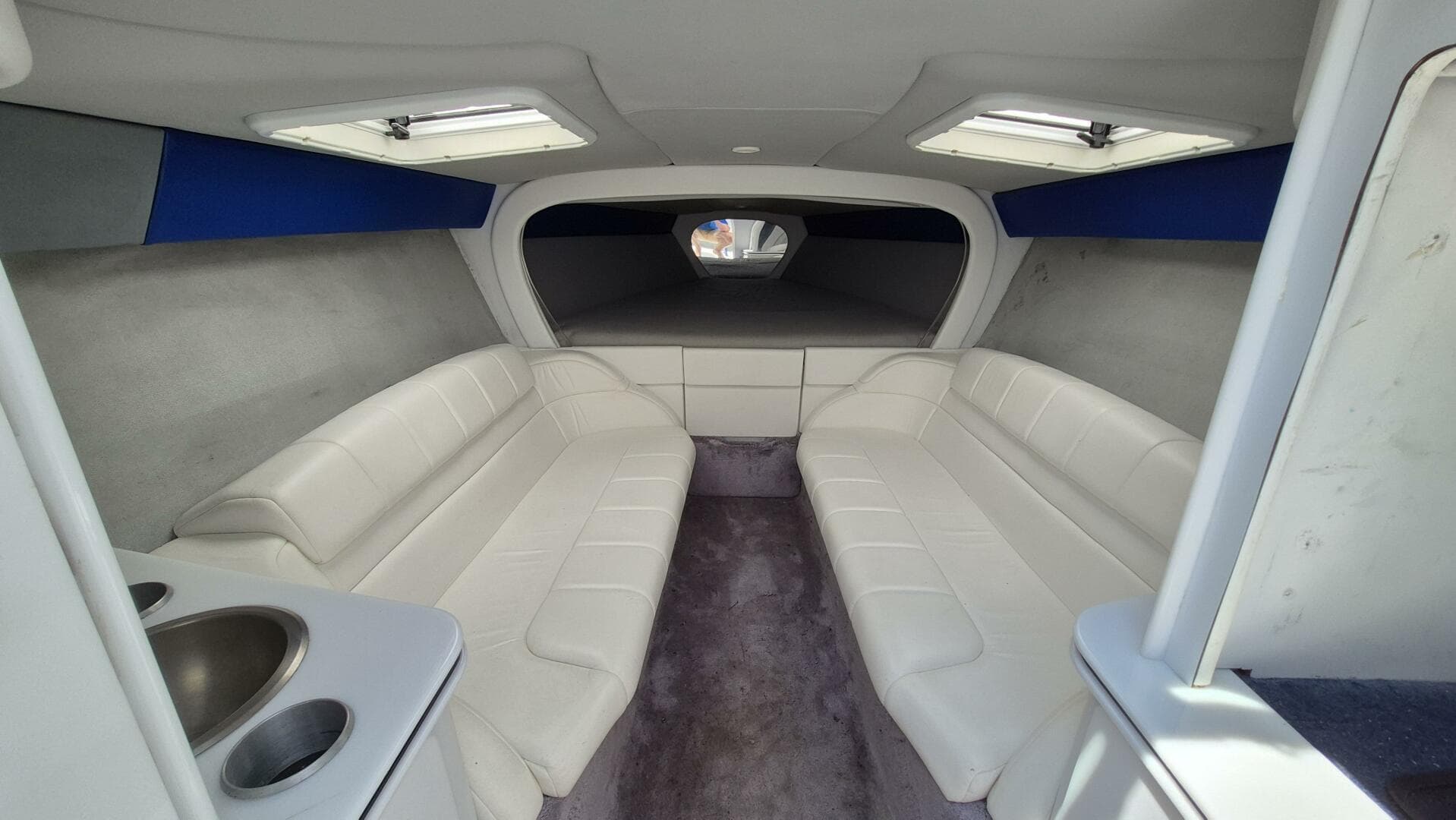 Interior of a 1999 Formula Fastech boat with white seating and skylights.