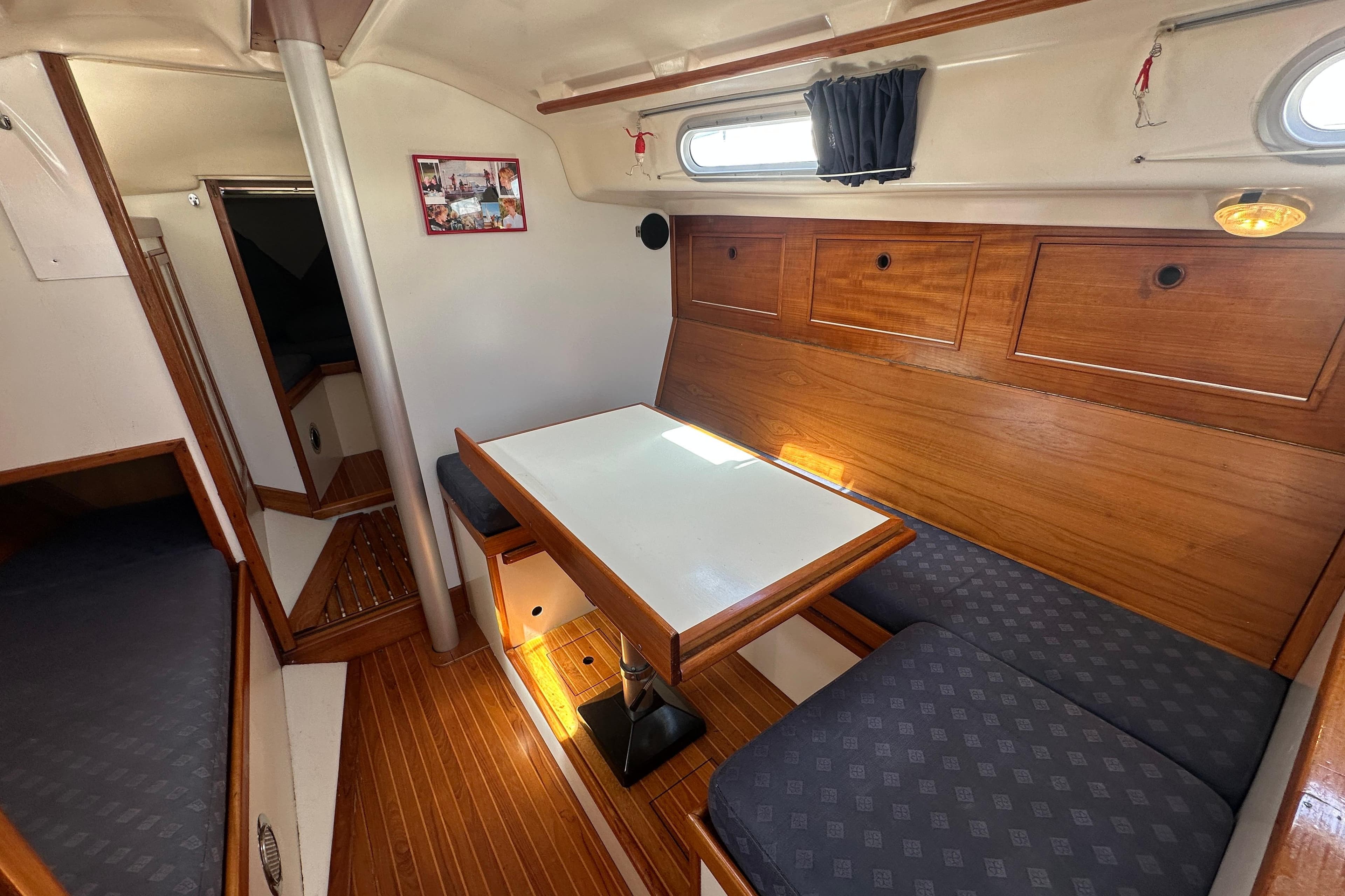 Interior of 1973 Wauquiez Centurion 32 sailboat with wooden cabinetry and seating area.