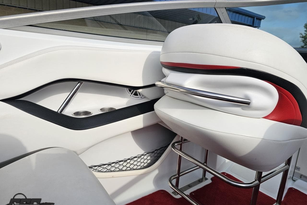 Interior of a 2004 Baja 275 boat featuring white and red seating with cup holders.