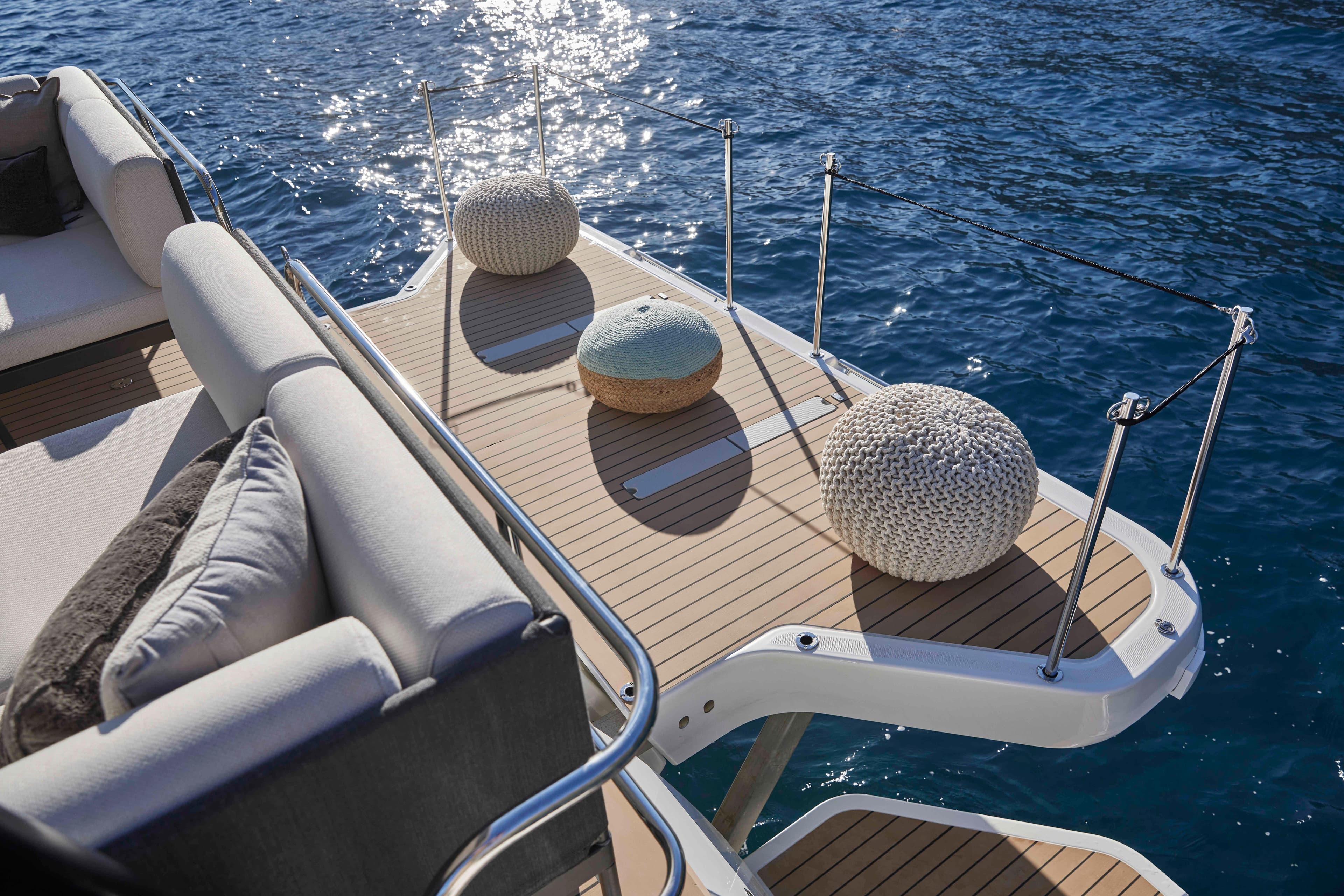Luxurious Prestige M48 yacht deck with cushions, overlooking sparkling blue water, 2025 model.