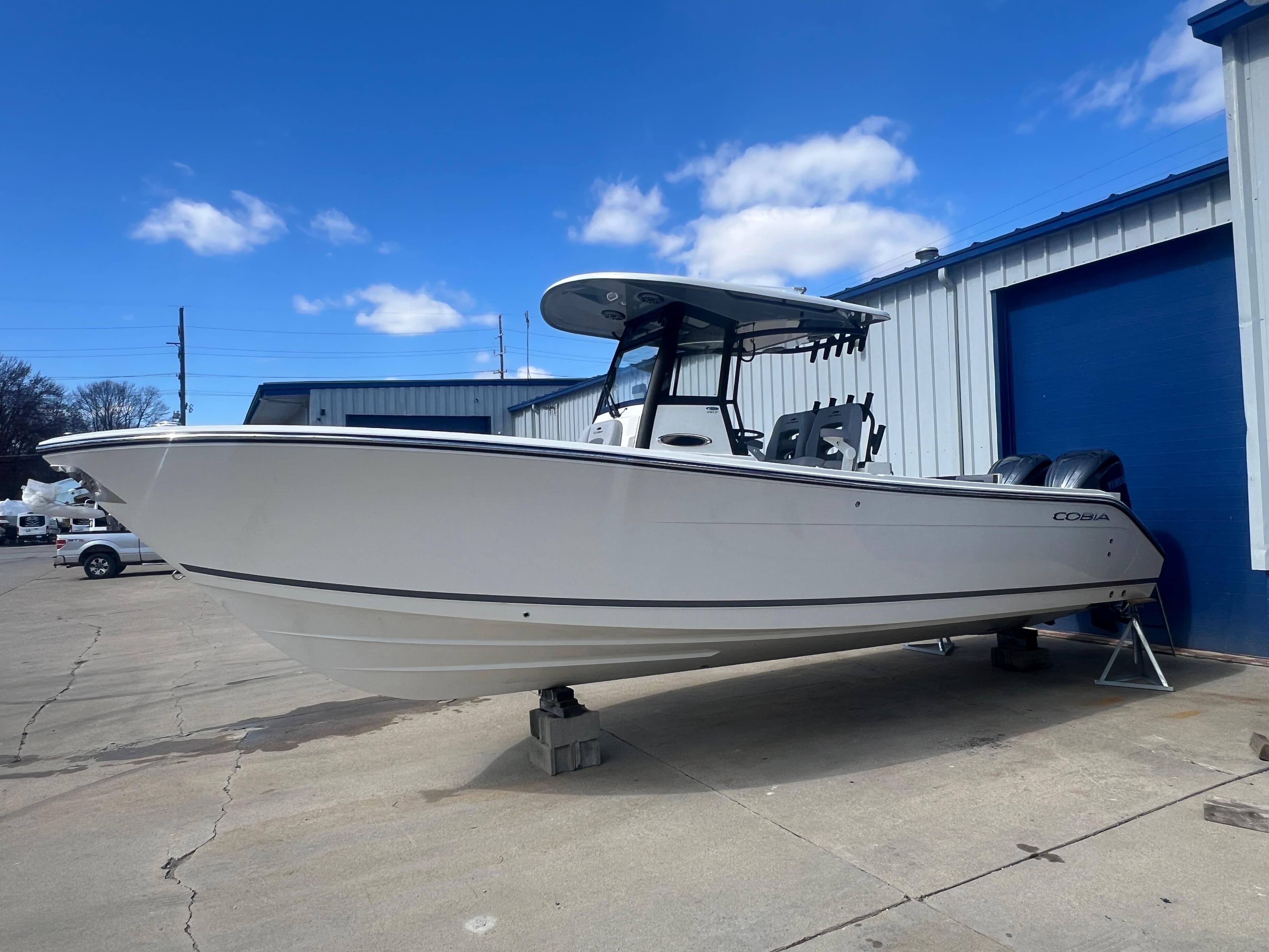2025 Cobia 285 Open Center Console boat on display outside a warehouse.