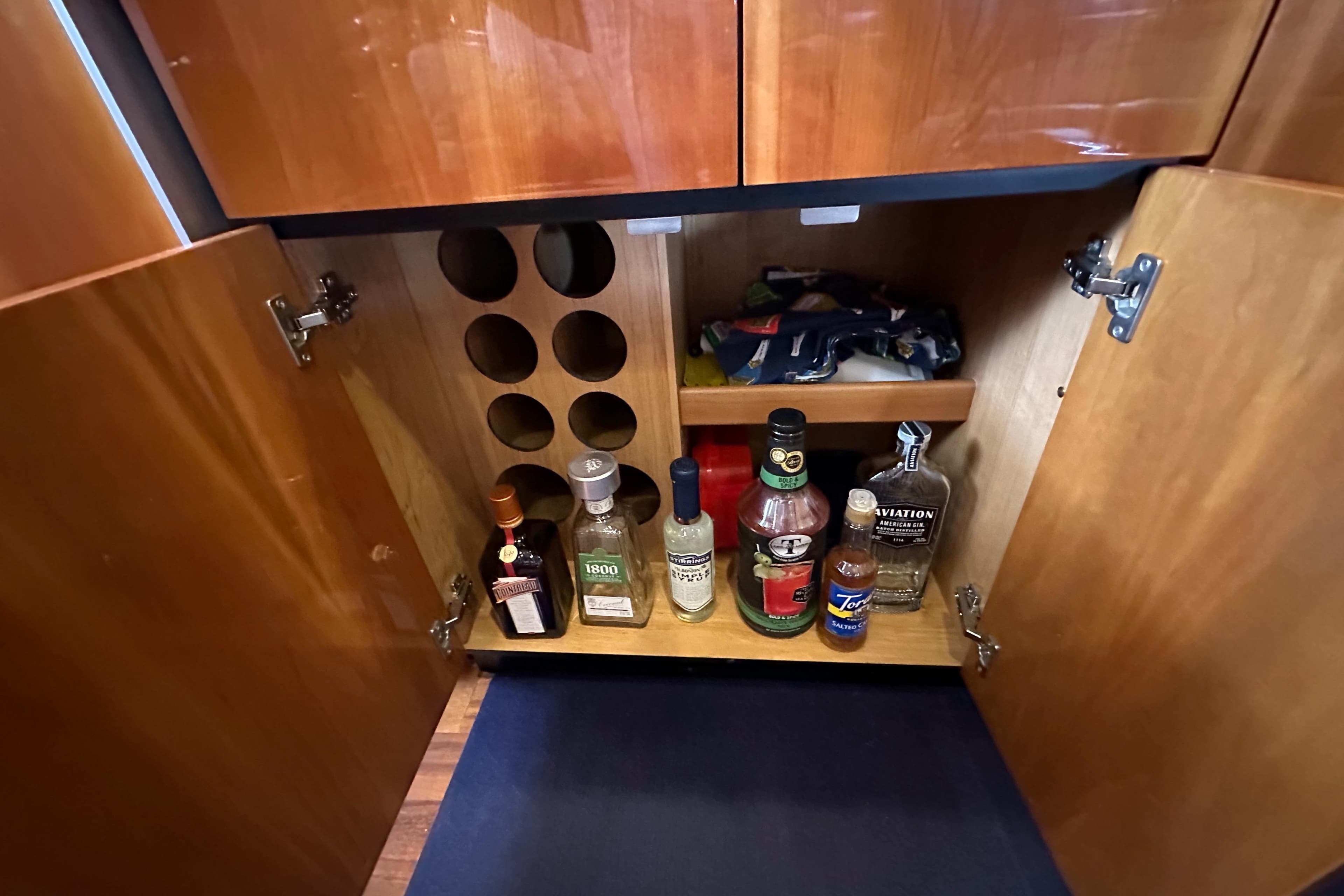 Liquor cabinet inside a 2000 Sunseeker Predator 60 yacht, featuring various bottles and storage.