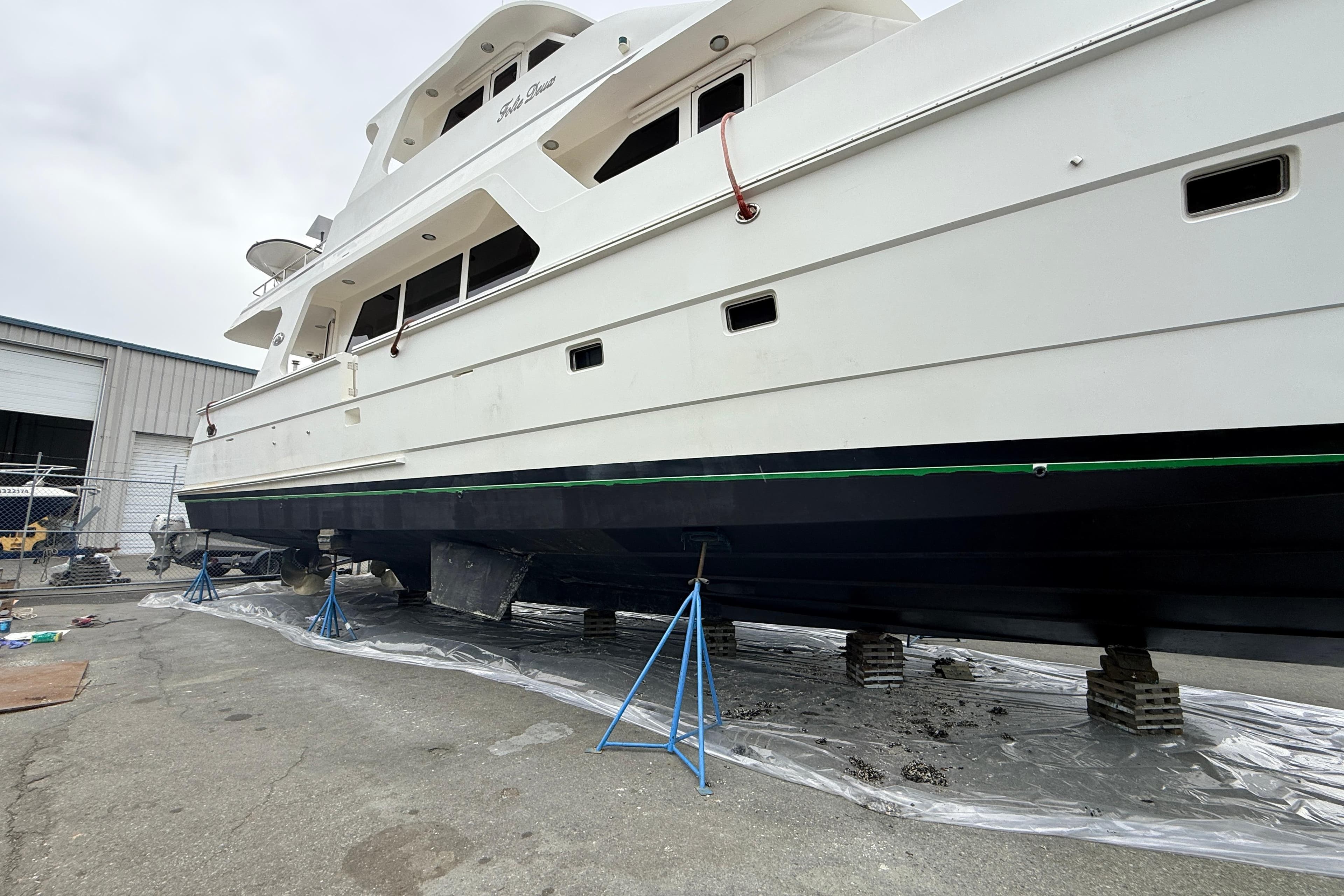 2005 President 680 Skylounge yacht on stands in a shipyard for maintenance.