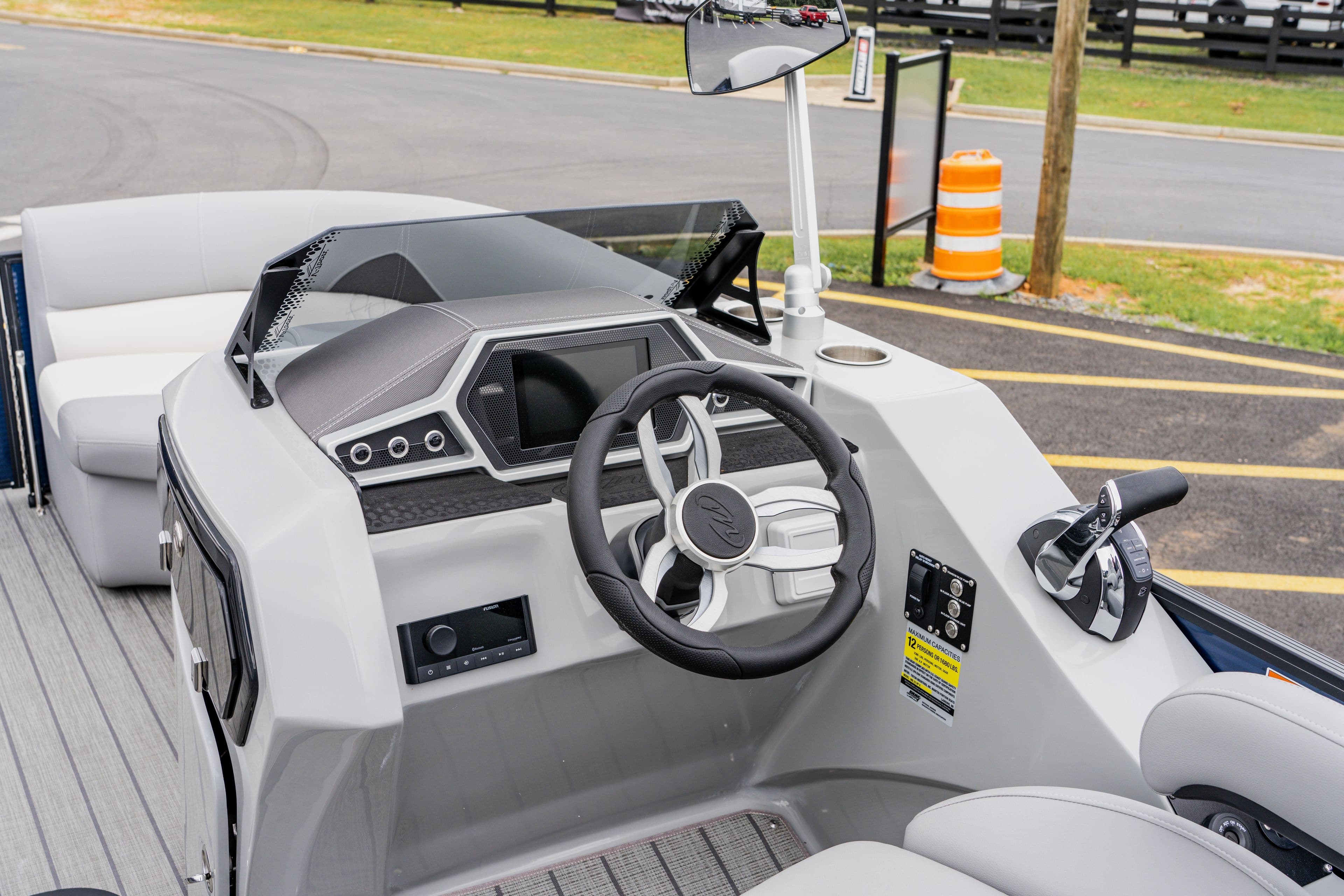 2022 Manitou 23 Encore boat dashboard with steering wheel and controls.