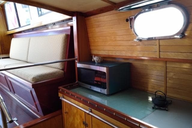 Interior of 1979 Mainship 34 Custom Sedan with wood paneling and kitchenette.