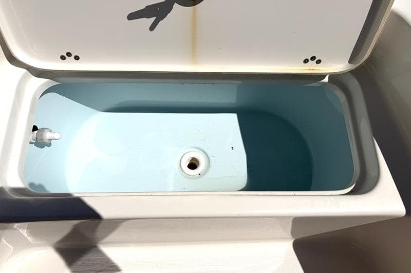 Open storage compartment on 2024 Key West 210 Bay Reef boat, showing interior details.