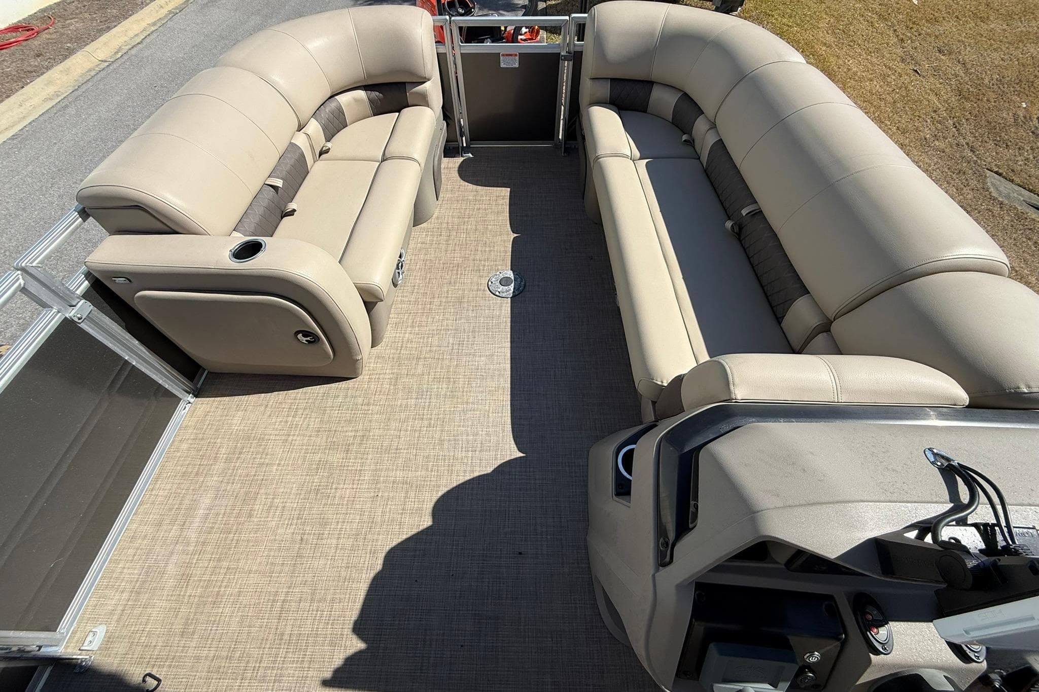 2024 Sun Tracker Party Barge 22 DLX interior with beige seating and spacious layout.