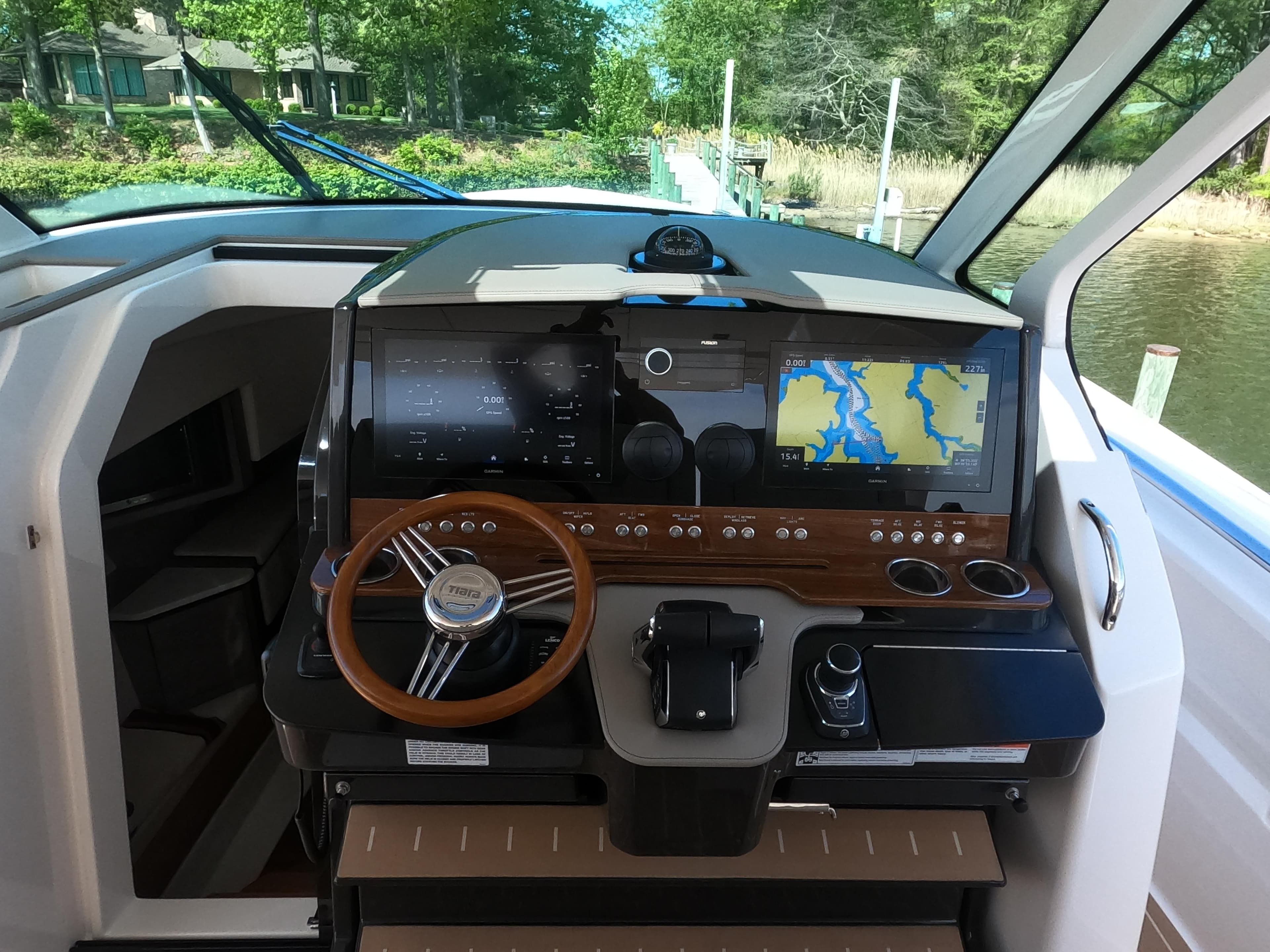 2024 Tiara Yachts 43 LS helm with advanced navigation system and wooden steering wheel.