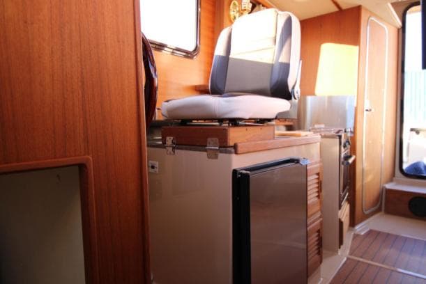 Interior of 2017 Ranger Tugs R-27 boat with seating and compact kitchen area.