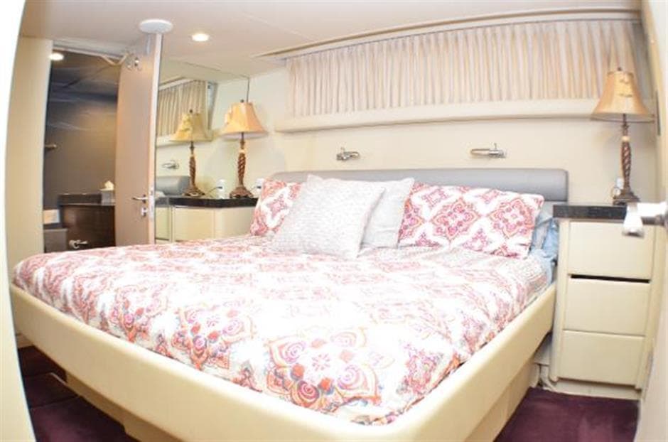 Luxurious bedroom in 1990 Broward Raised Pilothouse MY yacht with elegant bedding and decor.