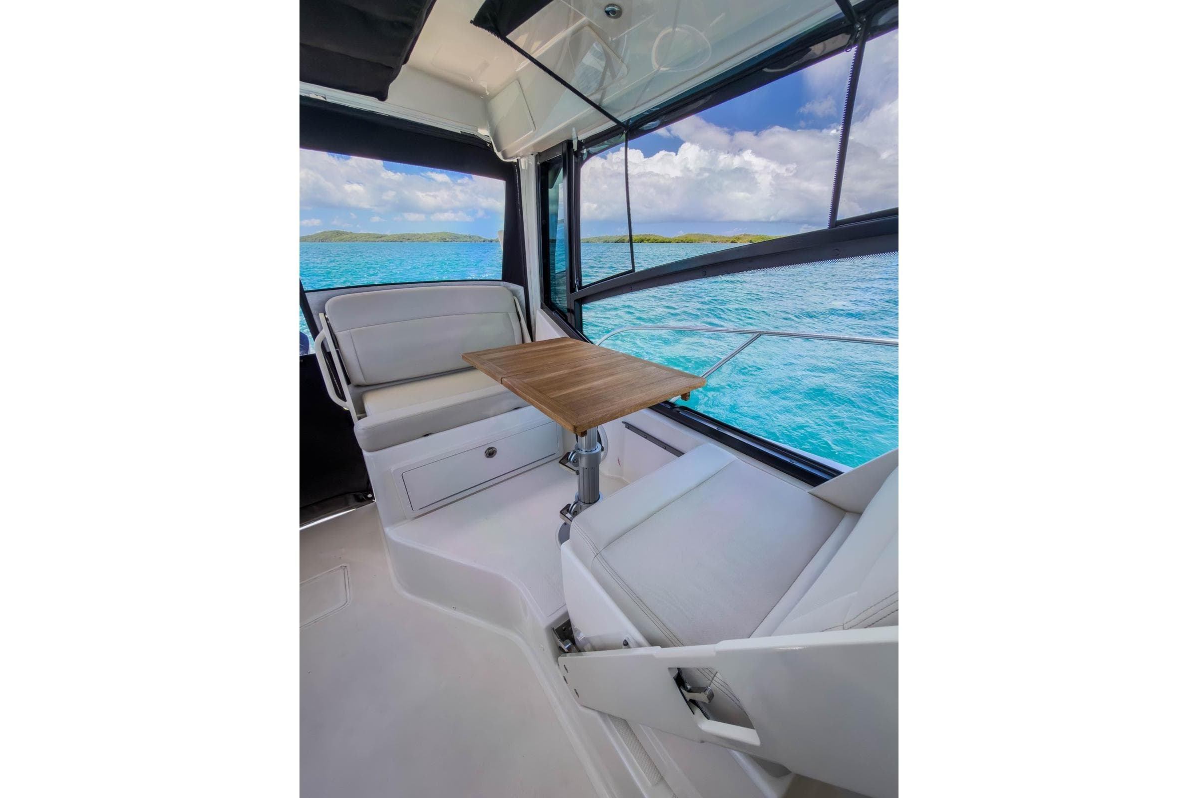 2024 Boston Whaler 325 Conquest interior with seating and table, overlooking ocean view.