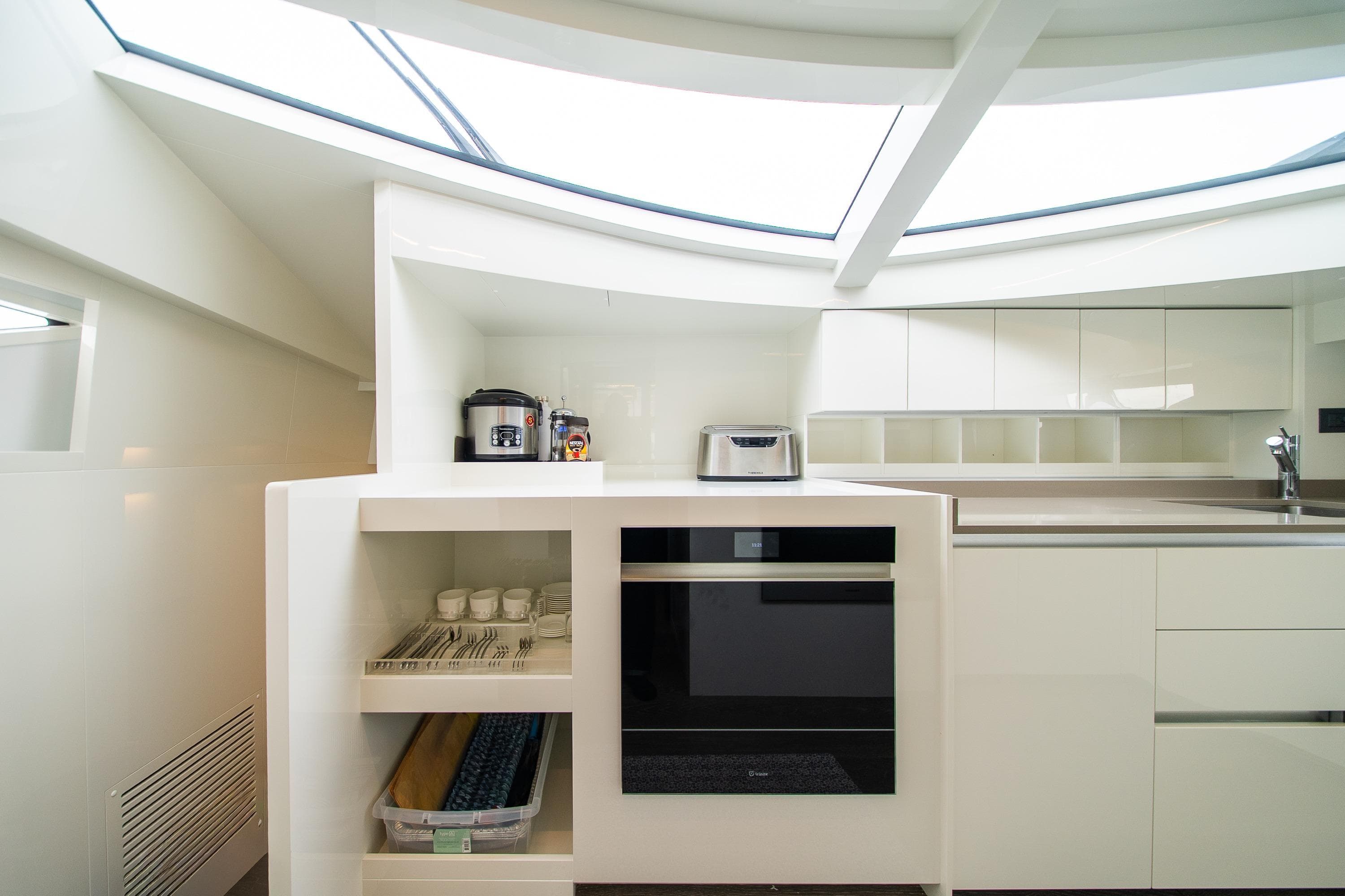 Modern kitchen interior on 2020 Ferretti Yachts 850, featuring sleek white cabinetry and appliances.