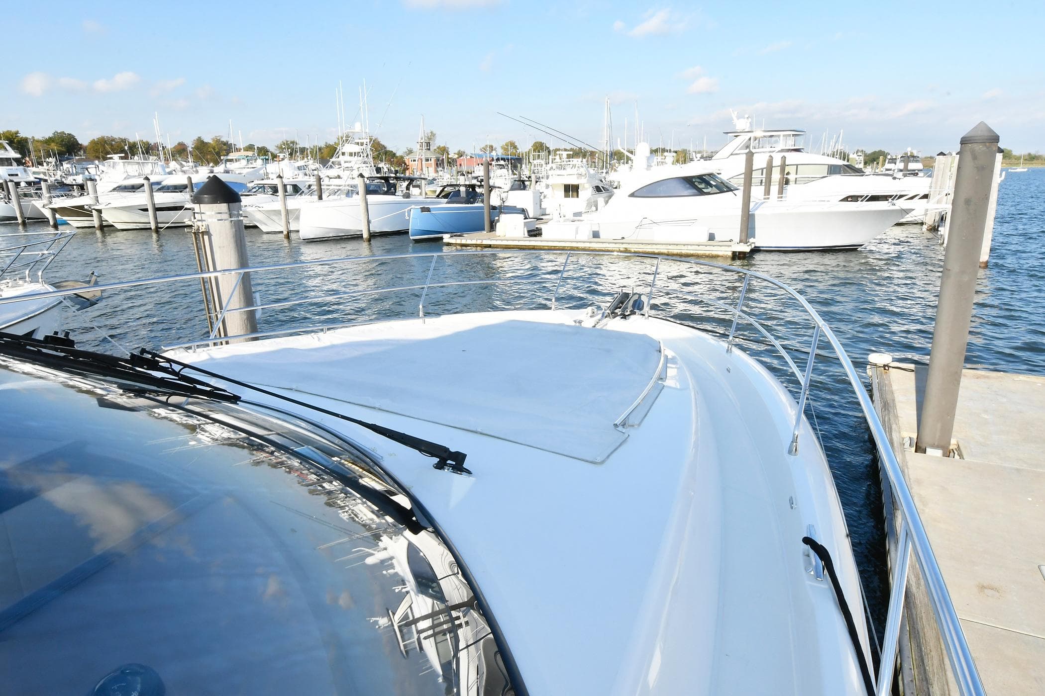 Prestige 560 Fly 2018 yacht docked at marina with other boats in background.