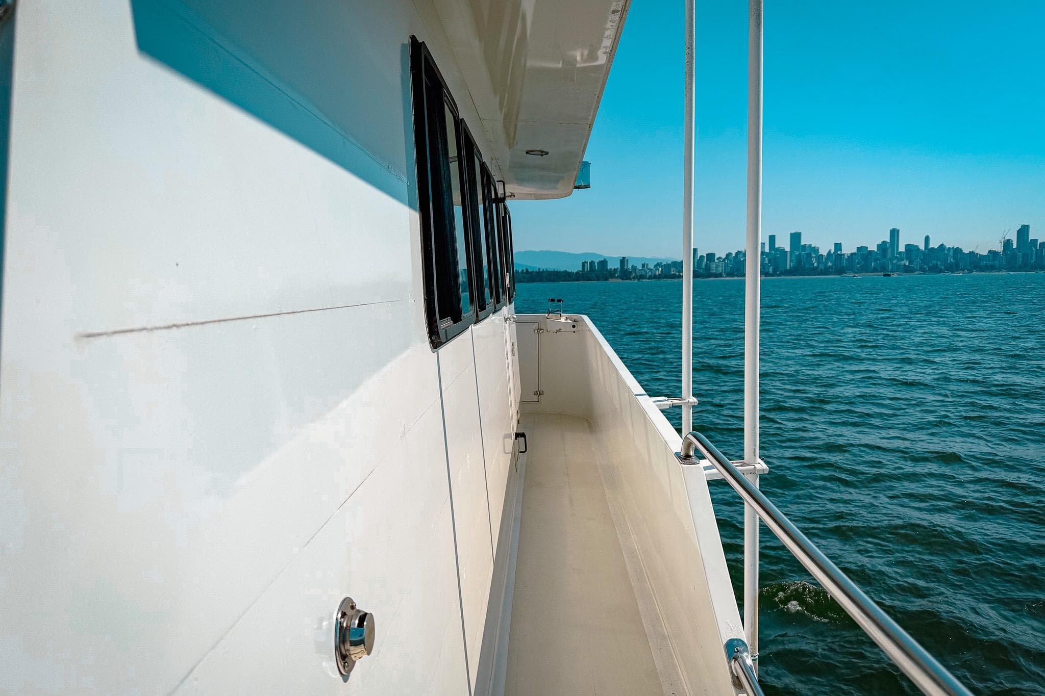 Side view of 2002 Darling Yachts Custom Aluminum, overlooking city skyline and ocean.