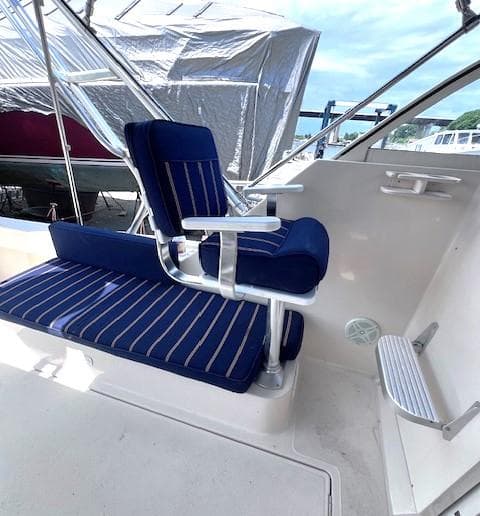2004 Mainship 30 Pilot Rum Runner boat with blue-striped seating and helm area.