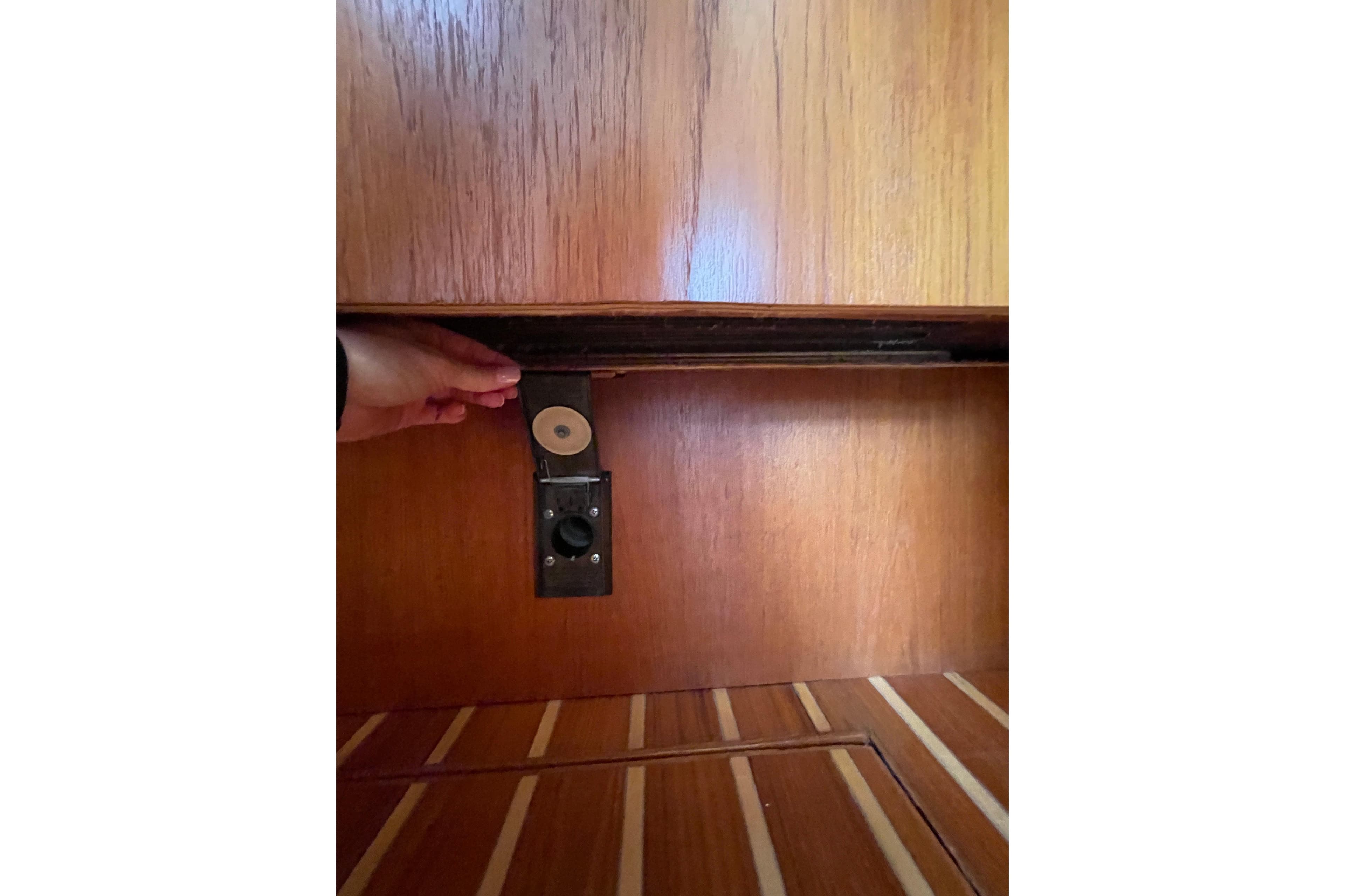 Hand adjusting mechanism inside 2009 Tiara Yachts 4200 Open wooden interior.