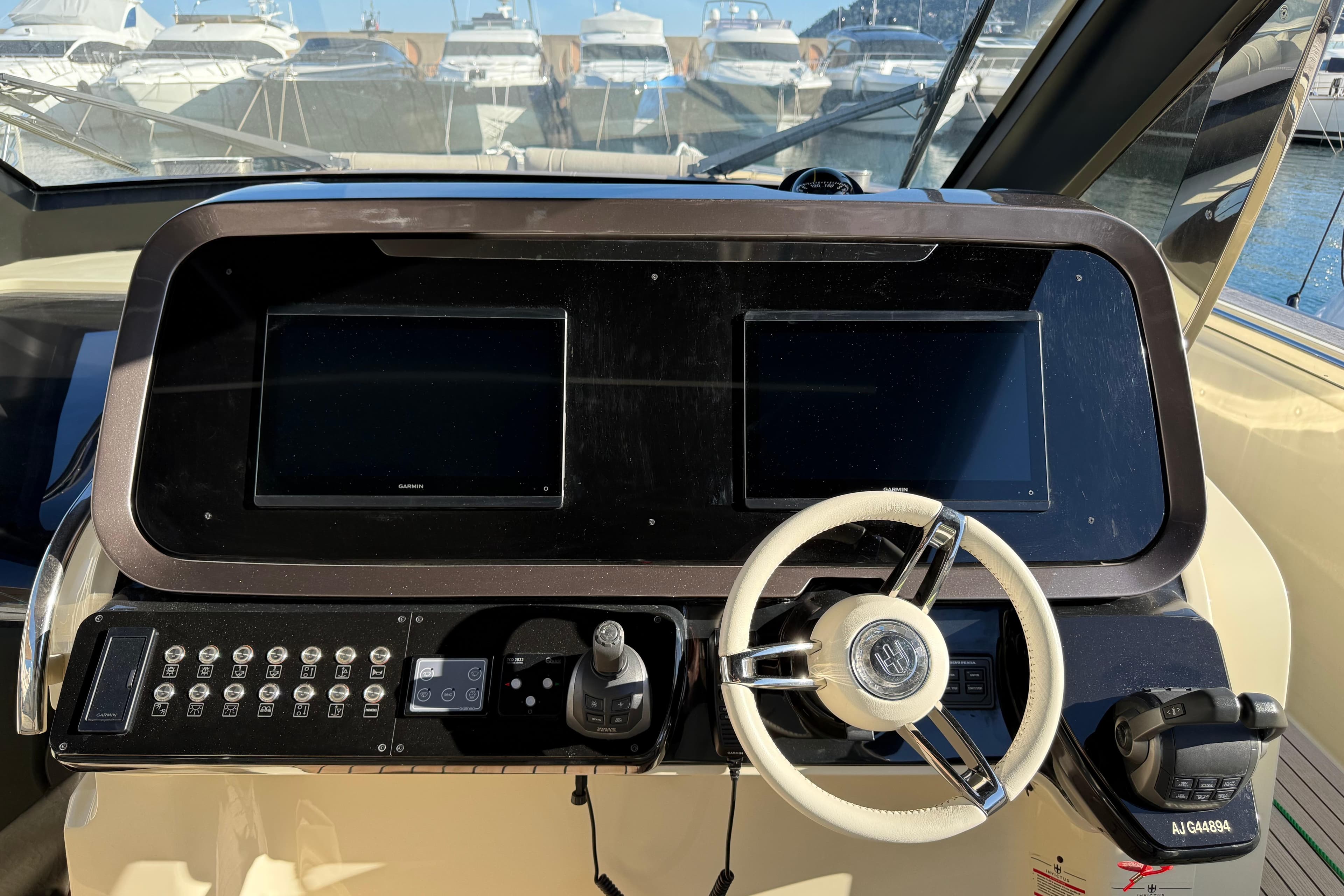 Cockpit of 2022 Invictus TT 460 yacht with dual screens and steering wheel.