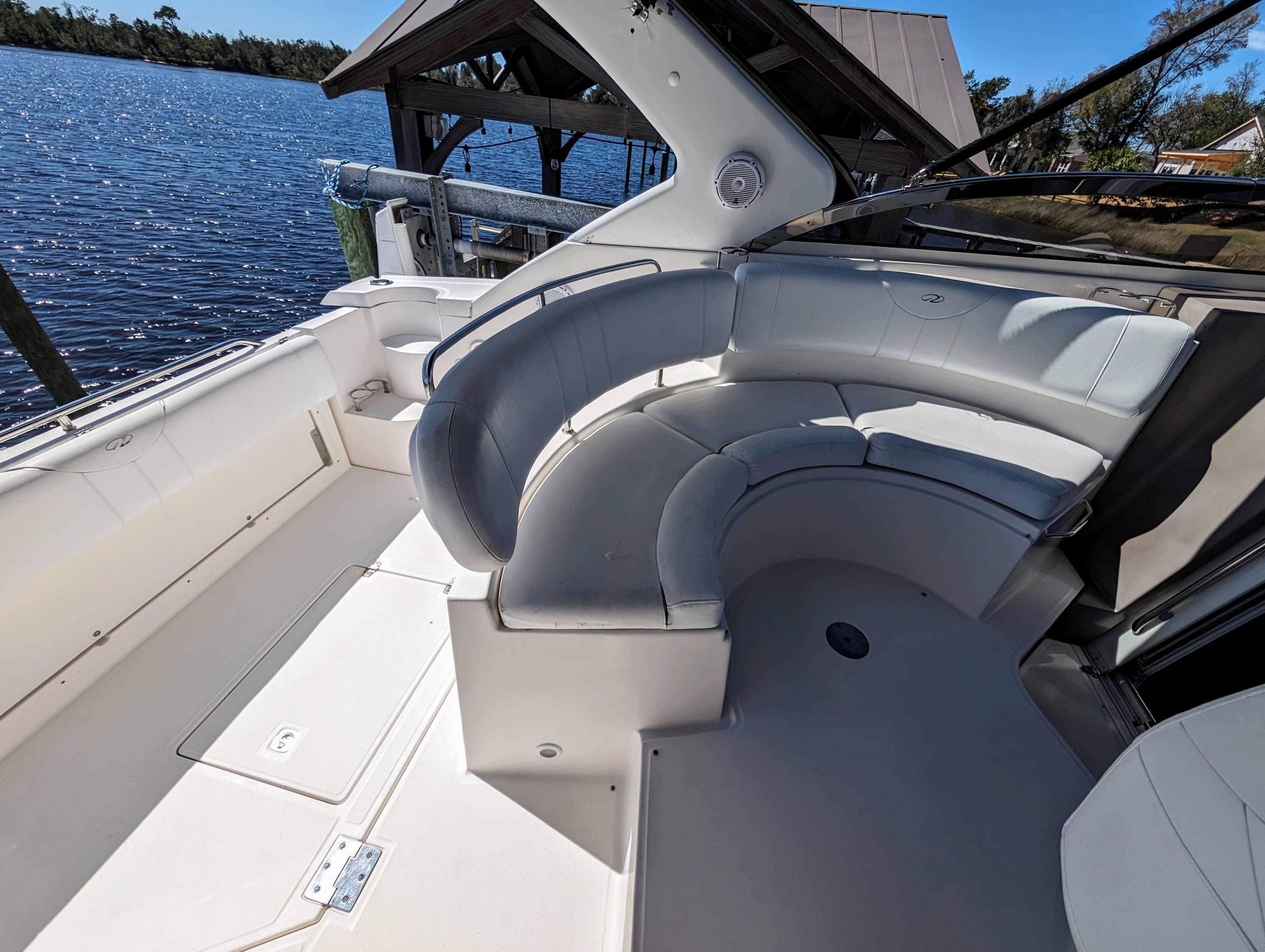 2005 Regal 3560 boat with spacious white seating area by the water.