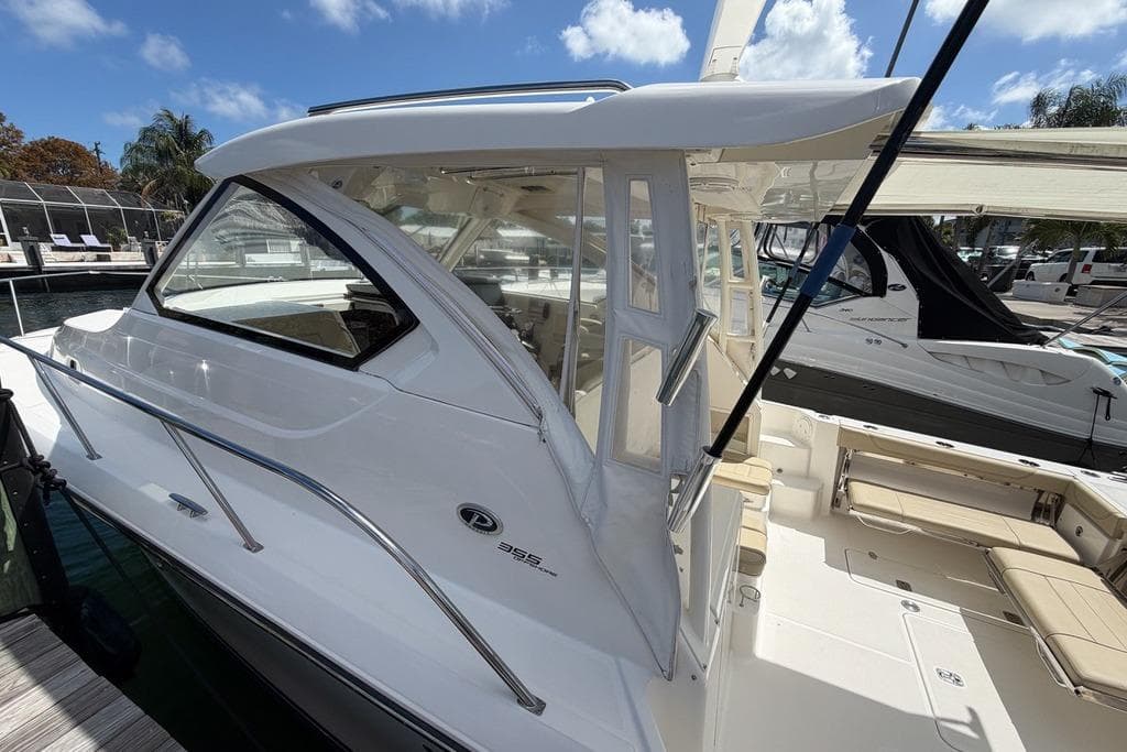 2018 Pursuit OS 355 Offshore boat docked under a clear blue sky.
